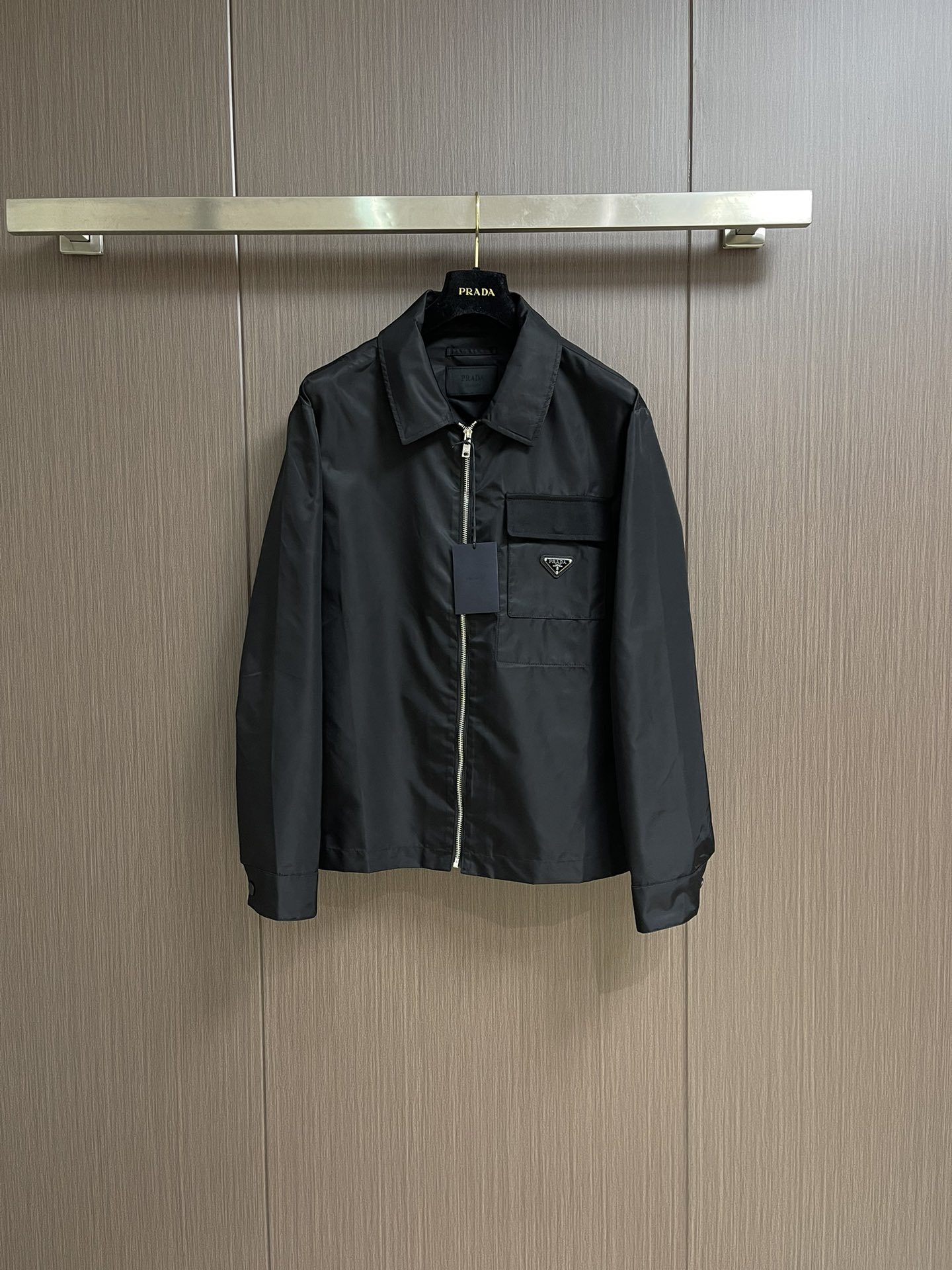 NO:141601,Prada and recycled nylon lapel jacket, the fabric is made of the brand's signature recycled nylon fabric, which is comparable to traditional nylon, and has high strength, tear resistance, wear resistance and other characteristics. Its texture is light and waterproof, and is suitable for multiple scene needs. Its wrinkle and quick drying are also easy to take care of and maintain on a daily basis. The straight sleeves and shoulder cut form smooth lines, matched with a flat bottom edge design, highlighting minimalism. Abandon traditional lining, shape the silhouette with the crispness of the fabric itself, reduce redundant layers while improving breathability. There is a patch pocket on the left chest, and a twill ginger flap highlights the layering, and the enamel triangle mark is decorated on the bag body to enhance visual recognition. The cuffs are made of concealed buckles to adjust elasticity, better fit the wrist, and provide comfort for wearing. Size S-XL, prada, jackets & coats, alexander wang19860909prada、再生尼龙翻领夹克,面料选用品牌标志性的再生尼龙面料,与传统尼龙性能相当,具备高强度,抗撕裂,耐磨损等特性.其质地轻盈,同时又具备防水功能适合多场景需求.抗皱,快干的特点也易于日常打理维护.直筒衣袖与落肩剪裁形成流畅线条,搭配平直底边设计,凸显极简主义.摒弃传统衬里,以面料本身的挺括度塑造廓形,减少冗余层次的同时提升透气性.左胸口设有贴袋,搭配斜纹格布翻盖凸显层次感,将涂珐琅三角标饰以袋体之上,强化视觉辨识度.袖口采用暗扣调节松紧,更好的贴合手腕,提成穿着舒适度.尺码S-XL,,prada,jackets & coats,alexander wang,Men's clothing