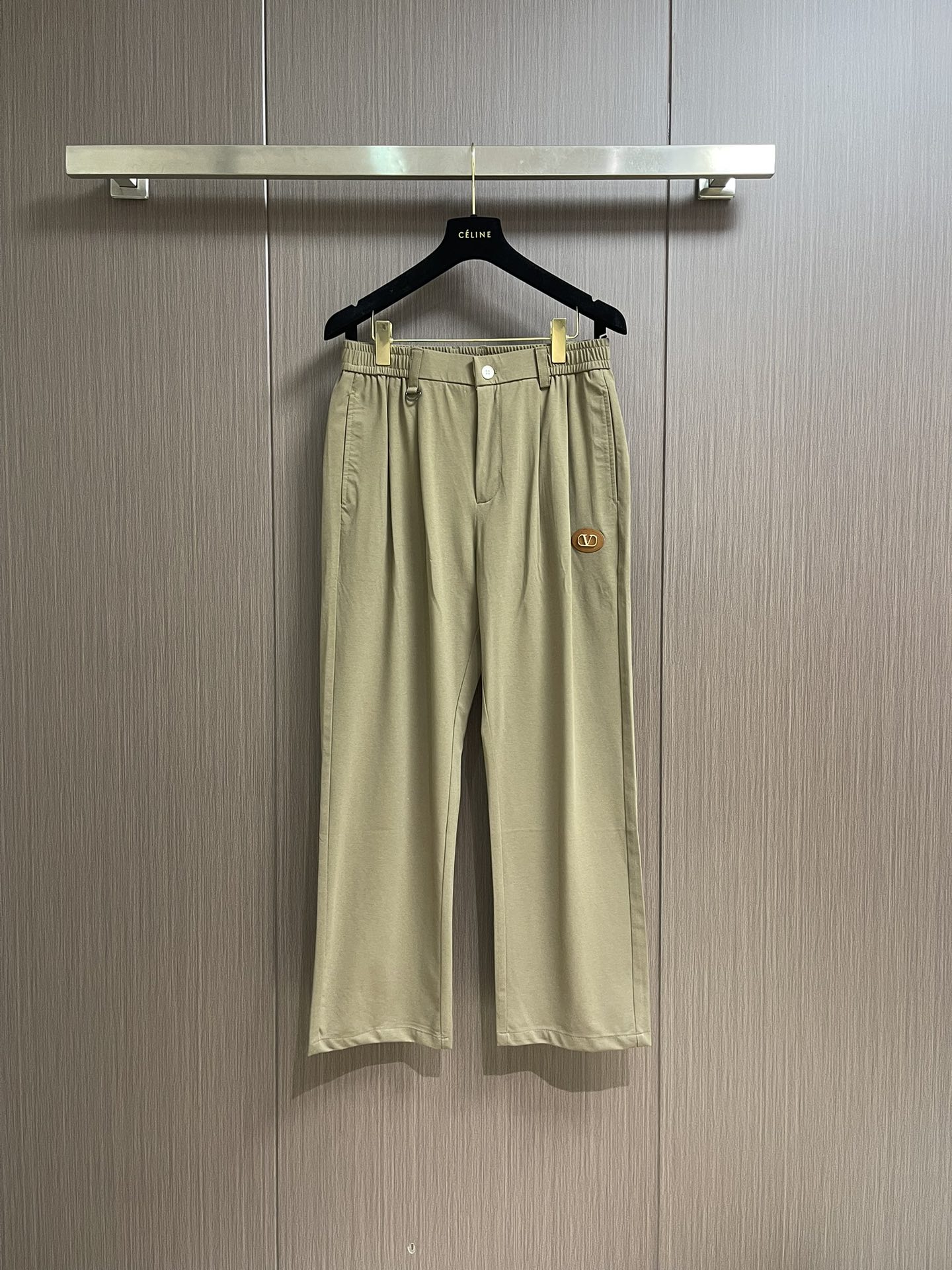 NO:155450,Valentino men's elastic waist drawstring straight pants, this casual pants combines fashion and comfort. The brown tone is classic and versatile, and is adapted to a variety of styles. The unique elastic band and metal ring design at the waist are matched with simple white buckles, which not only ensure comfort while adding ingenuity to detail. The iconic oval leather logo is decorated with metal 
