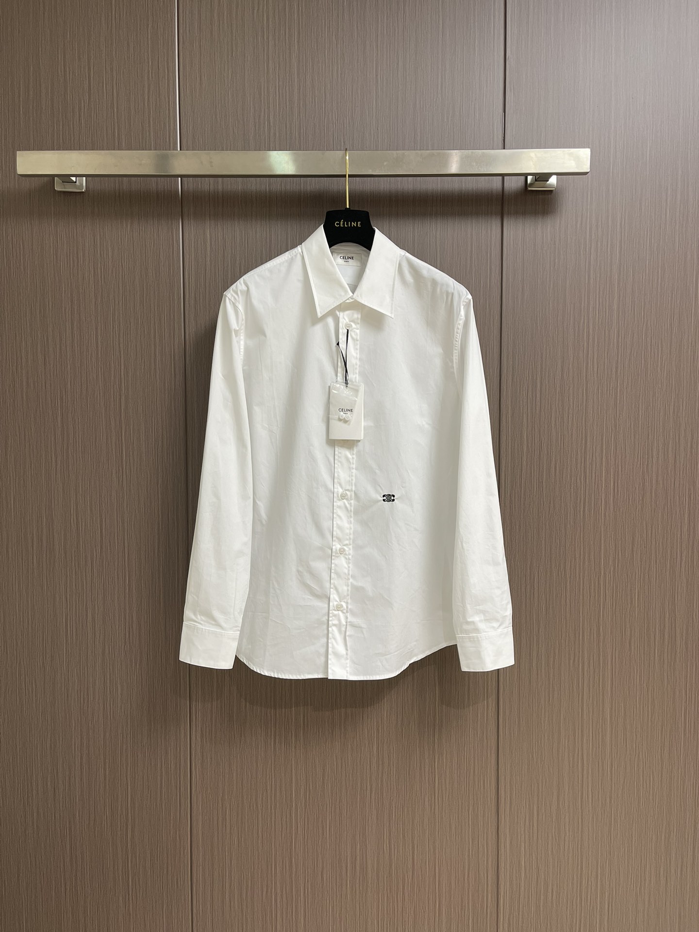 NO:415367,celine  Solid color embroidered long-sleeved shirts are made into thin and extremely breathable fabrics through a weaving process of high-strength cotton yarn with high warp and low weft density. The surface is smooth and smooth, and the touch is as smooth as silk. At the same time, the cotton is natural skin-friendly and comfortable, and it is not unusual. Because the warp yarns are tightly arranged, the fabric surface presents a longitudinal texture and soft luster, which enhances the visual sense of high-end. The monochrome flat embroidery of the front piece controls the coordinated operation of the machine head, needle rod and spool through the high-precision computing system of the computer embroidery machine. The fabric frame moves accurately in horizontal and vertical directions to form a stitch trajectory, and adjusts the upper line and lower  Line tension ensures that the stitches are flat and there are no floating lines, forming a fine pattern with an error of ±0.1mm. The ironing machine turns the collar upside down, irons from the bottom to the upper end through high temperature and humid steam, applies pressure to smooth the wrinkles, and then turns to the front and repeats the operation. Turn to the collar and burn it out, and press the collar to the bottom to maintain a firmness. The rotator cuff part uses the hanging method to avoid crushing the edges. After adjusting the fiber density through the ironing machine's 'push, return, and pull' technology, the shirt better fits the human body curve. Size 46-52, celine, shirts, alexander  wang19860909celine 纯色饰刺绣长袖衬衫,通过高支棉纱经密高,纬密低的织造工艺制成轻薄且具有极佳透气性的面料.表面光滑平整,触感如丝绸般柔滑,同时保留棉的天然亲肤性,贴身舒适无异样感.因经纱紧密排列,织物表面呈现纵向纹理与柔和光泽,强化视觉高级感.前片的单色平绣通过电脑绣花机高精度的计算系统控制机头、针杆、线轴的协同作业,布料框架在水平和垂直方向精准移动,形成针迹轨迹,调整上线和下线张力,确保线迹平整无浮线,形成误差在±0.1mm的精细图案,熨烫师将衣领翻立,通过高温湿蒸汽从底部向上端熨烫,施加压力抚平褶皱,再翻至正面重复操作.转至领口烫出弧形,后领压至最底以保持挺括.肩袖部分利用悬空法避免压死边缘.通过熨烫师的'推、归、拔'技术调整纤维密度之后,使衬衫更好的贴合人体曲线.尺码46-52,,celine,shirts,alexander wang,Men's clothing