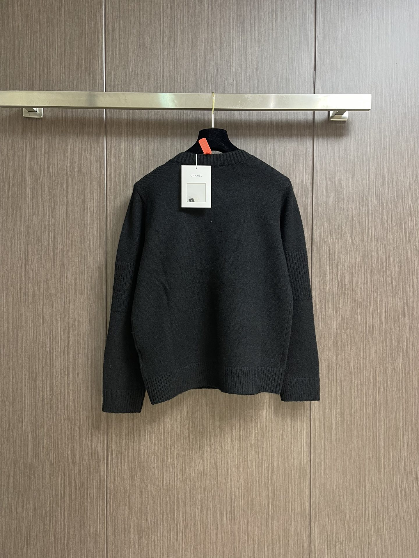 
Chanel 书包扣长袖针织毛衣，定织百花绒镶羊毛织料。肩部巧妙融入标志性香奈儿书包扣设计，采用接缝立