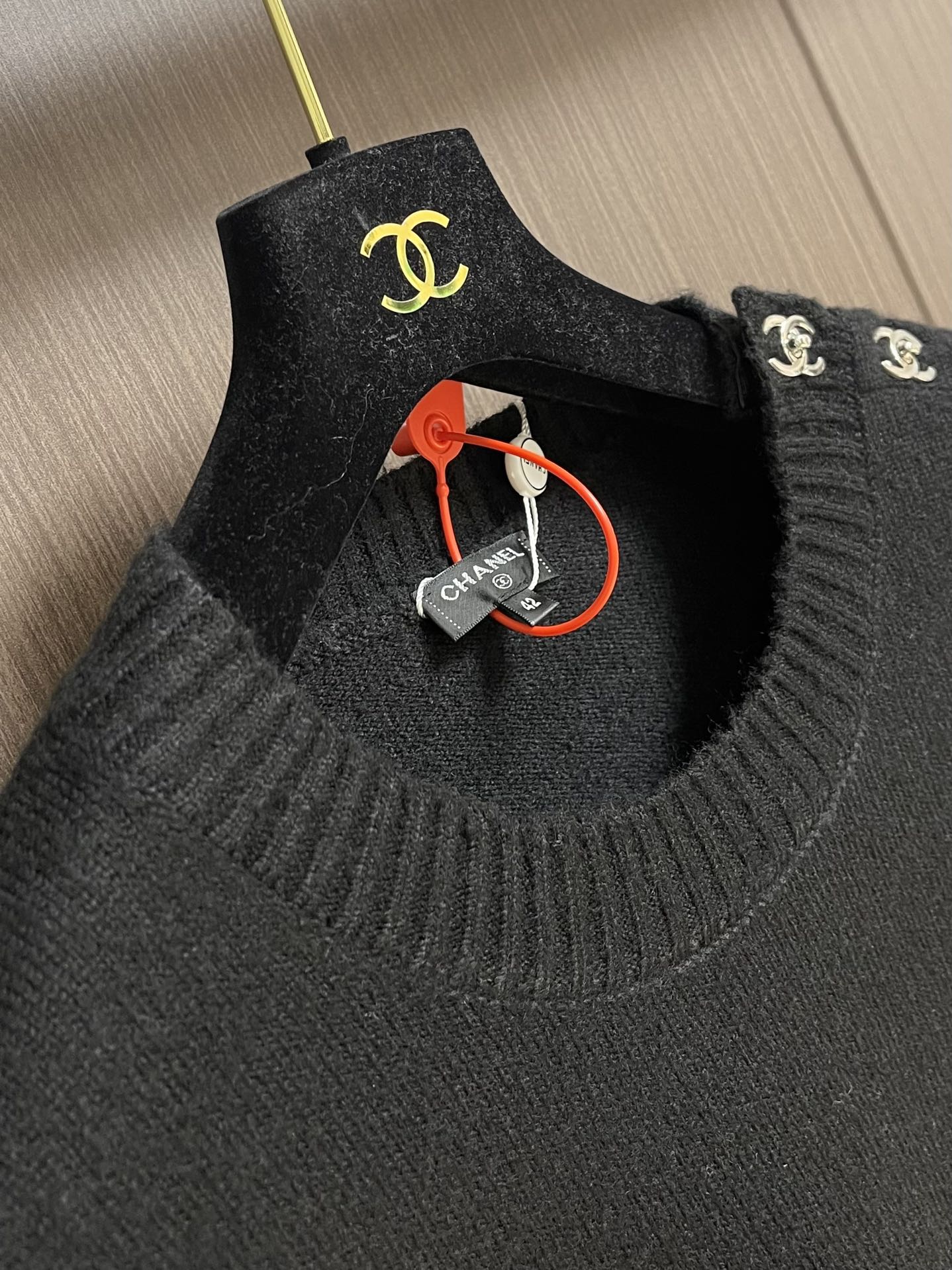 
Chanel 书包扣长袖针织毛衣，定织百花绒镶羊毛织料。肩部巧妙融入标志性香奈儿书包扣设计，采用接缝立