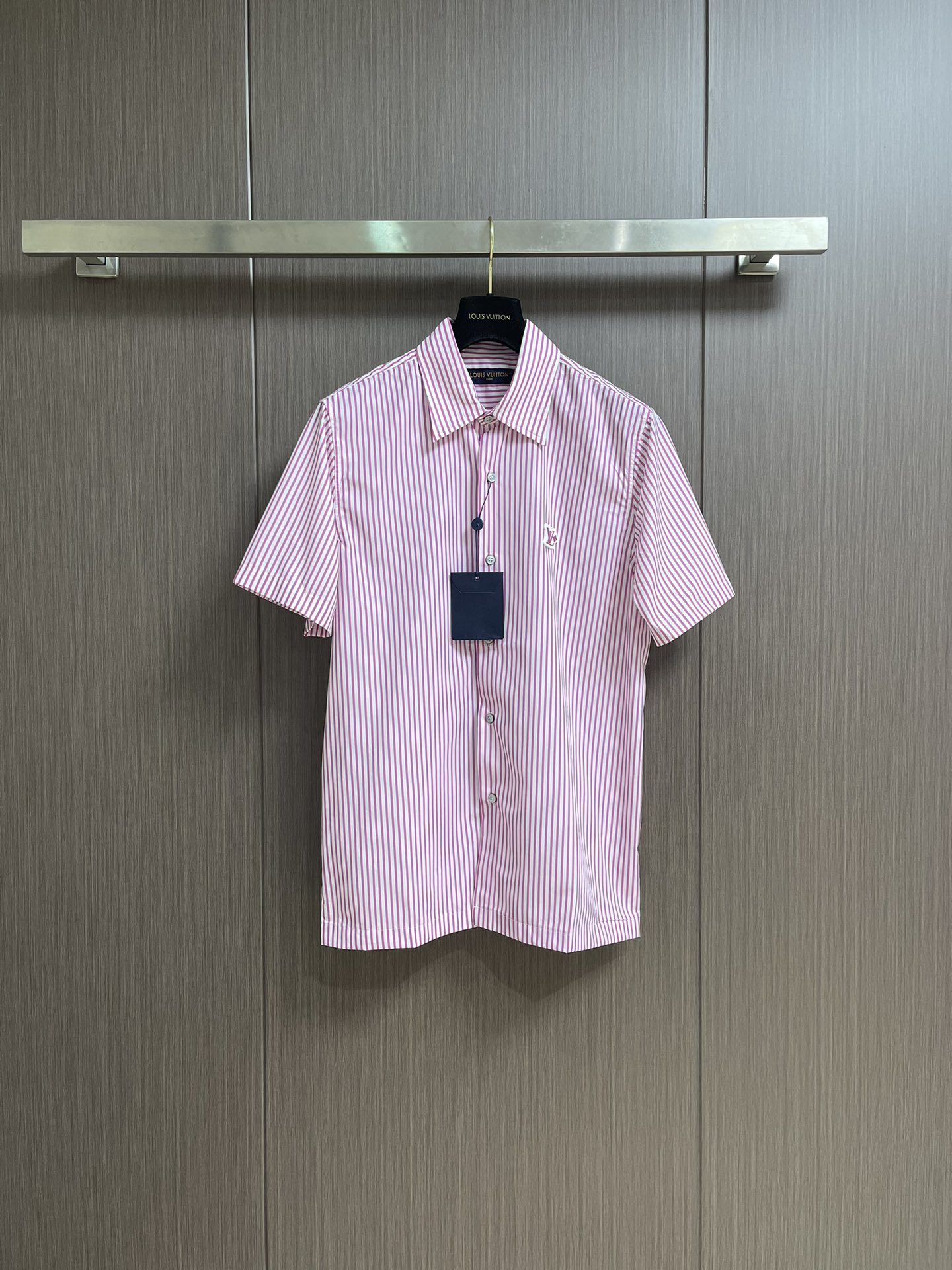 NO:461448,LV striped contrasting color short-sleeved shirt is made of high-quality cotton, with soft and comfortable texture. The fabric is made of classic Monogram jacquard and bright striped prints on the surface to form a unique visual sense of layering. The standard design is designed with exquisite pointed collar shapes, and pearlescent buttons are selected at the details and metal bases to highlight the exquisite craftsmanship of the brand. The Flower rubber patch specially designed on the chest becomes the finishing touch, highlighting the brand's logo and adding a three-dimensional texture to the whole. It can be perfectly matched with the same series of striped items to create a layered layered layered shape. The fabric has been specially treated to ensure that it is clean and stylish while maintaining the natural breathability of cotton. Every detail has been carefully considered, from jacquard weaving to printing technology to embellishment, all reflect the ultimate pursuit of quality. Size S-XL,,louis  vuitton,shirts,T-shirt,alexander wang19860909LV 条纹撞色短袖衬衫,采用优质棉料制成,质地柔软舒适.面料以经典Monogram提花为底纹,表面叠加鲜明条纹印花,形成独特的视觉层次感.采用标准版型设计,搭配精致的尖领造型,细节处选用珠光纽扣并配以金属底座,彰显品牌精湛工艺.胸前特别设计的 Flower橡胶贴饰成为点睛之笔,既突出了品牌标识,又为整体增添立体质感.该可与同系列条纹单品完美搭配,打造富有层次感的叠穿造型.面料经过特殊处理,确保穿着挺括有型,同时保持棉质的天然透气性.每一处细节都经过精心考量,从提花织造到印花工艺,再到点缀,无不体现对品质的极致追求.尺码S-XL,,louis vuitton,shirts,T-shirt,alexander wang,Men's clothing