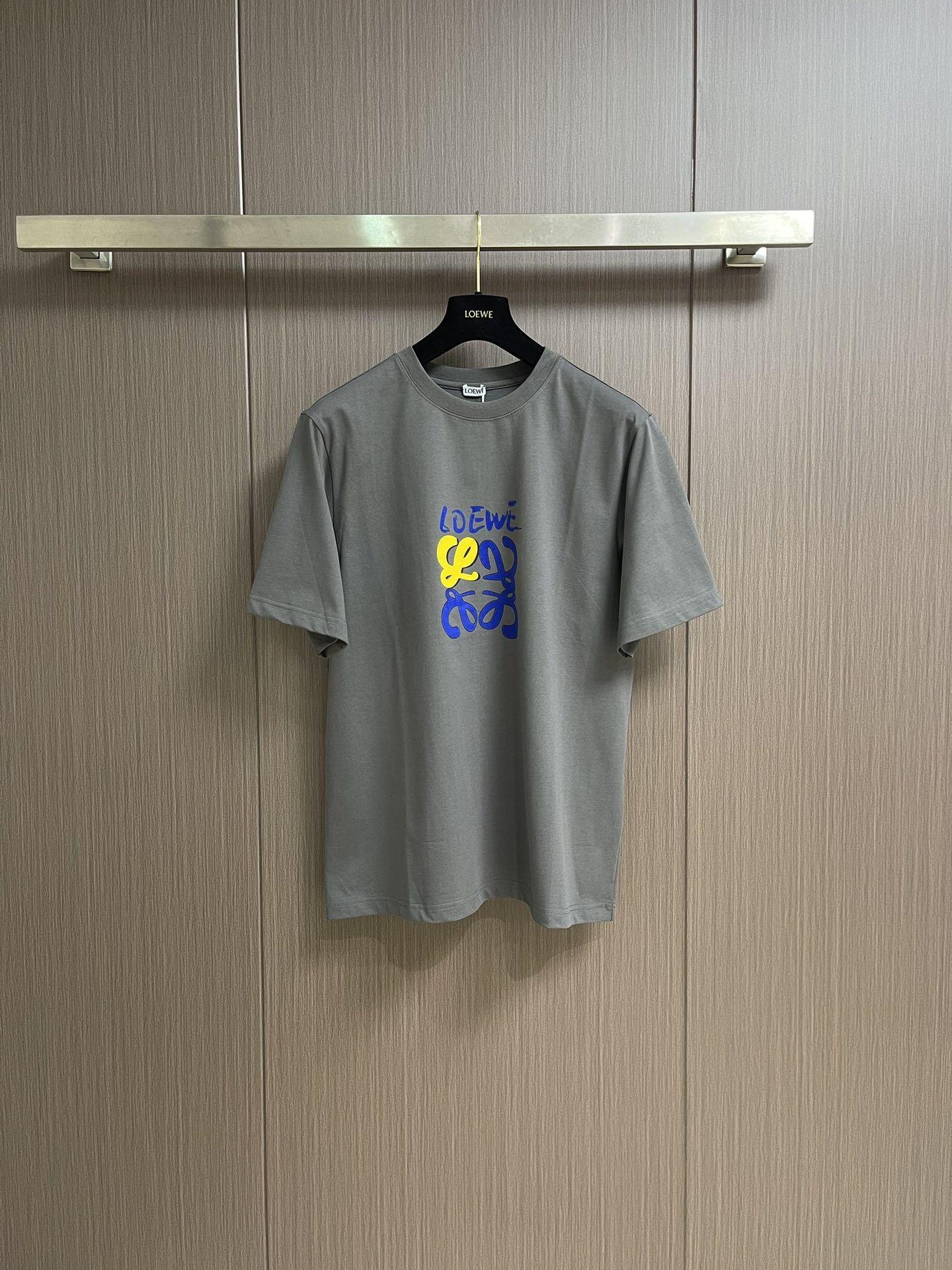 NO:455511,loewe colorful graffiti printed short-sleeved T-shirt, a collision of street art and comfort, this short-sleeved piece brings street graffiti art into daily outfits!  Tightly knitted cotton fabric, skin-friendly and textured, comfortable to wear close to the body, as if wrapped in clouds. The gray background is simple and high-end, the LOEWE colorful graffiti print on the chest is super eye-catching, the yellow and blue color combination is lively and eye-catching, breaking the monotony, and the street trend is full. Whether it is a boy who is cool and handsome on the street or a girl who plays with her underwear missing, she can easily grasp the fashionable style. Size XS-L,,loewe,T-shirt,tees,t-shirt,alexander wang19860909loewe 炫彩涂鸦印花短袖T恤,街头艺术与舒适的碰撞,这件短袖,把街头涂鸦艺术搬进日常穿搭！紧密针织棉面料,亲肤又有质感,贴身穿舒适到像被云朵裹住.灰色底色简约又高级,胸前LOEWE炫彩涂鸦印花超吸睛,黄蓝配色活泼亮眼,打破单调,街头潮流感拉满,不管是男生酷帅出街,还是女生玩下衣失踪、都能轻松拿捏时髦范儿.尺码XS-L,,loewe,T-shirt,tees，t-shirt,alexander wang,Men's clothing