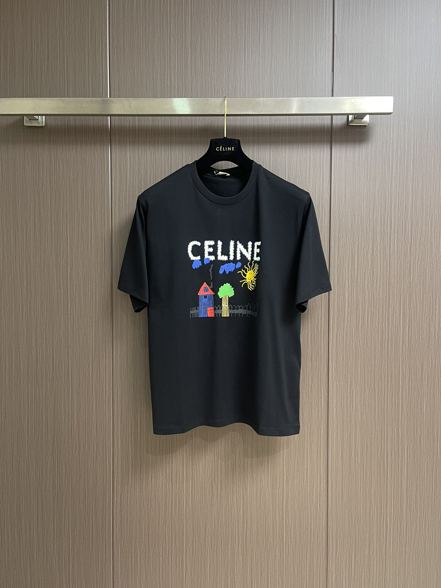 NO:458910,Celine Children's Fun Painting Print Round Neck Short-Sleeve T-shirt, Pure Cotton Fabric, Children's Fun Painting Print, Loose Style, Round Neck Short-Sleeve, Collar Ribbed, Full Set of Auxiliary Materials, 50S Double-Strand Mercerated Cotton, 165g gram weight; matched with 32S  1x1 tie-up thread, 300g. The thinner the yarn, the higher the number of branches, the fabric made is usually softer, smoother and finer. Two yarns are used and twisted together. This can enhance the strength and durability of the fabric and make the feel more full. The cotton fiber is treated with a concentrated caustic soda solution to make the fiber surface smoother and increase the gloss and softness of the fabric. Children's fun graffiti painting printing, adjust the same color material according to the original color special, and choose high elastic tie-up glue printing. Increase the elasticity of the printing part, and the penetration is strong, especially on all cotton fabrics. The details between the printing are very well processed, without burrs and cross-border marks.  By technically processing the printed screen, the patterned paste can pass through the fabric, with strong permeability and clear and visible fabric texture. The dots are used in the local area, and the distribution of dots is very dense, so the printed pattern has extremely high clarity and resolution. High-density dot paste printing technology is used to print various complex patterns and textures on clothing. Due to the special properties of the paste, the printed pattern has a certain attractiveness, unique visual effect, and a delicate touch. Size S-M-L, celine, T-shirt, tees, t-shirt, alexander  wang19860909Celine 童趣绘画印花圆领短袖T恤,纯棉质面料、童趣涂鸦绘画印花、宽松版型、圆领短袖、衣领饰有罗纹、全套辅料配备 采用50S双股丝光棉,克重165g；搭配32S 1x1拉架螺纹,300g.纱线越细,支数越高,制成的面料通常越柔软、光滑且精细.使用了两根纱线并捻在一起.这样做可以增强面料的强度和耐用性,手感更加饱满.棉纤维经过浓烧碱溶液处理,使纤维表面变得光滑增加了面料的光泽度和柔软度.童趣涂鸦绘画印花,根据原色特调同色胶浆材质,选择高弹拉架胶浆印刷.增加印花部位弹力,同时渗透力色牢度较强,尤其在全棉面料上效果更好.印花之间细节处理非常到位,无毛边及过界痕迹.经过对印刷网版进行技术处理,使有图案的地方浆料能够透过到织物上,渗透性强且面料纹路清晰可见.局部采用网点浆印刷技术,网点的分布非常密集因此印刷出的图案具有极高的清晰度和分辨率.利用高密度网点浆印花技术在服装上印刷出各种复杂的图案和纹理,由于浆料的特殊性质,印刷后的图案具有一定的吸引力,视觉效果独特,而且触感细腻.尺码S-M-L,,celine,T-shirt,tees，t-shirt,alexander wang,Men's clothing