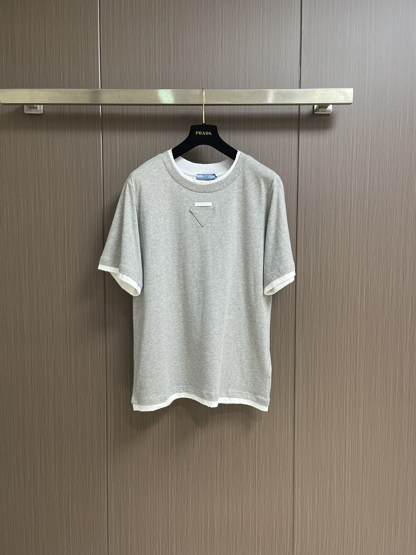 NO:478909,Prada 2025ss new fake two-piece triangle logo round neck short-sleeved T-shirt, giving the wardrobe basic items a new personality through hierarchical design. Jersey clothes are loose in shape and decorated with the same color triangle logo. Sizes S-M-L, prada, T-shirt, tees, t-shirt, alexander wang19860909Prada 2025ss新款假两件三角标识圆领短袖T恤,通过层次设计赋予衣橱基础单品新的个性.平纹针织衣物呈现宽松廓形,并以同色三角形徽标装饰.尺码S-M-L,,prada,T-shirt,tees，t-shirt,alexander wang,Men's clothing