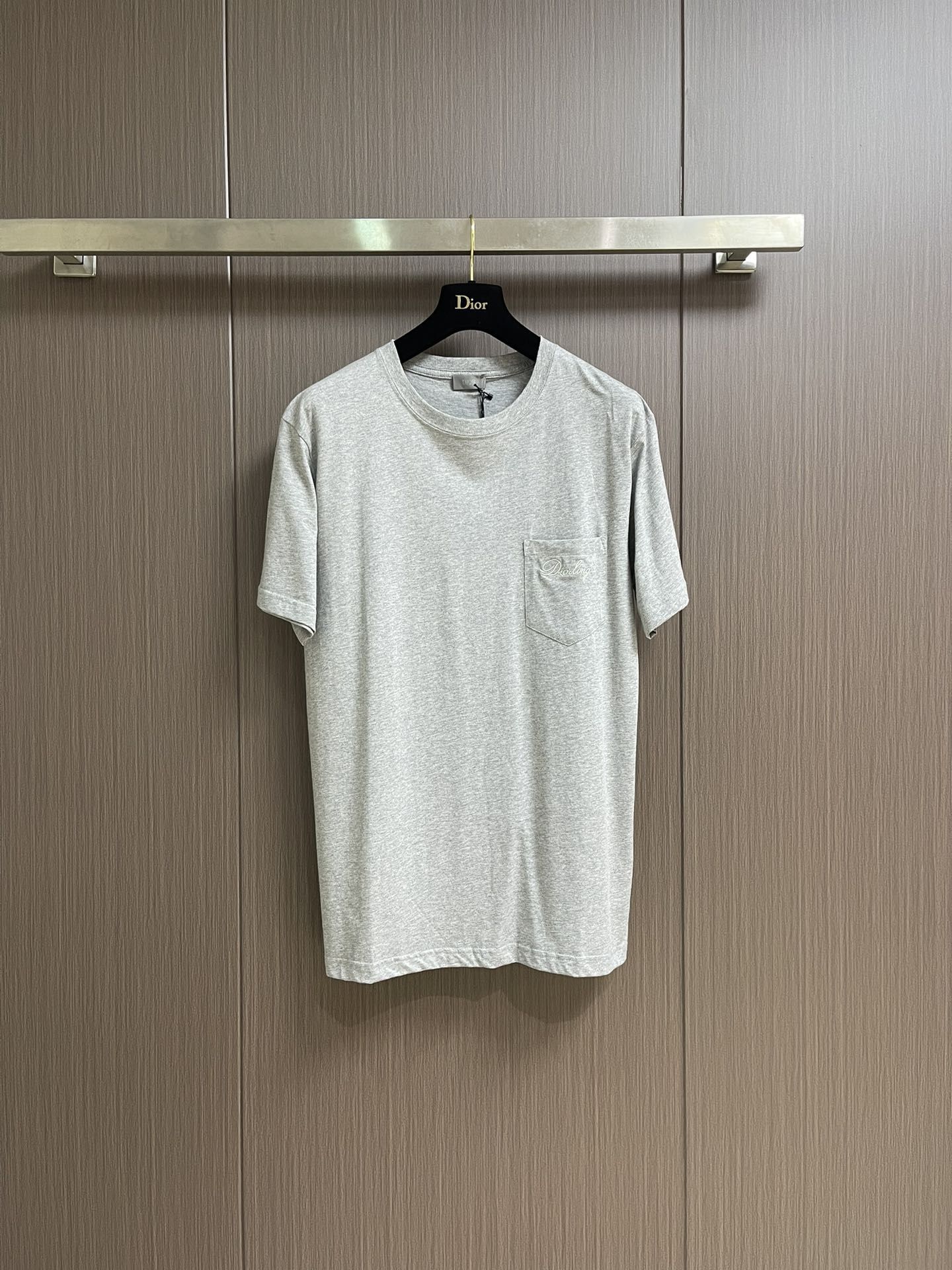 NO:504550,Dior cotton jersey round neck T-shirt, this T-shirt is a new product in the 2025 winter series. It is decorated with Dior Love embroidery inspired by Dior archives, paying tribute to Dior. It is carefully crafted from gray cotton jersey fabric with ribbed round neck. The regular version can be easily matched with finely tailored and oversized versions. The chest is decorated with Dior Love embroidery  Ribbed round collar, chest pocket embroidery logo is sewn with three-dimensional needle-to-face embroidery process. The multi-layered needle arrangement brings a slightly convex three-dimensional visual effect, with clear and smooth details, and rounded edges of letters, improving the overall delicateness and artistic sense. (The embroidery pattern is stable and firm on the soft cloth surface, and is not easy to fall off thread, showing the fine control of embroidery texture and texture of Dior Workshop, which is a perfect combination of brand craftsmanship and design concept.) High-spec 24 tight yarn 185g cotton fabric, woven by precision knitting technology. The fabric feels soft and delicate, comfortable to touch the skin, has good breathability and elasticity, and takes into account anti-allergic and wear resistance, showing the quality, thickness and skin-friendly feeling that high-grade knitted cotton materials should have.  Double yarn ribbed neckline splicing, more textured at the details, good fit and not easy to deform, and more durable daily wear. Size XS-L,,dior,dior,tees,t-shirt,alexander wang19860909Dior 棉质竹节平纹针织圆领T恤,这款T恤是二零二五冬季系列新品,饰以灵感源自迪奥档案的迪奥之爱刺绣,向迪奥承传致敬.采用灰色棉质竹节平纹针织面料精心制作,搭配罗纹圆领.常规版型,可与精裁和超大版型轻松搭配.胸前饰以迪奥之爱刺绣 罗纹圆领,胸前口袋刺绣标识,采用立体挨针绣线工艺缝制.多层次的针法排列带来微凸的立体视觉效果,细节清晰流畅,字母边缘收针圆润,提升整体细腻度与艺术感.（刺绣图案在柔软布面上稳定牢固,不易脱线,展现迪奥工坊对于刺绣纹理与质感的精细把控,是品牌工艺与设计理念的完美结合.)高规格24支紧密纱185g棉质面料,采用精密针织工艺织就.面料手感柔软细腻,触肤舒适,具备良好的透气性与弹性,同时兼顾抗敏、耐磨等性能,展现出高级针织棉料应有的品质厚度与亲肤感. 双纱罗纹领口拼接,细节处更显质感,贴合度佳且不易变形,日常穿着更为耐久.尺码XS-L,,dior,dior,tees，t-shirt,alexander wang,Men's clothing