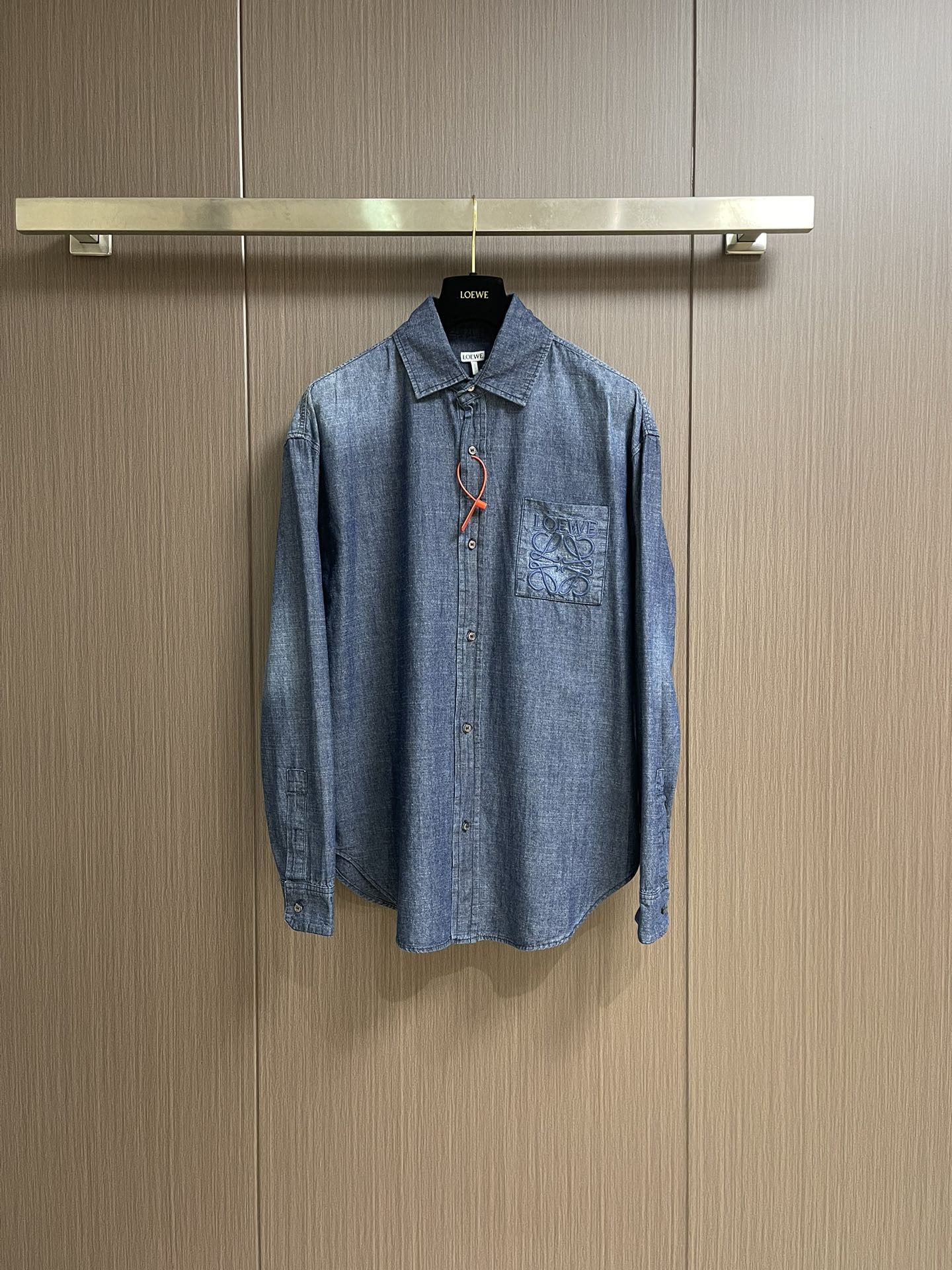 NO:502709,Loewe Anagram Gradient embroidered pocket shirt, customized high-quality cotton youth cloth expensive fabric, with a unique washing gradient blue as the main tone, from deep to shallow, from thick to light, with Loewe on the chest patch pocket decorated with Loewe  Anagram embroidery is the soul, engraved with LOEWE casual and elegant, natural and smooth lines, which show their freedom and freedom. The imported machine embroidery uses advanced computer control systems and precise mechanical components to realize Loewe embroidery operations. Gradient dynamic spray dyeing technology uses special spray dye to accurately spray the dye onto the surface of the fabric in a mist form (by precisely controlling the spray dyeing equipment's spraying speed and direction in combination with the movement speed and direction during the dyeing process) to present a smooth and natural transition effect of the color. Butterfly clamping pleats are used to inspire the beautiful form of butterflies, and through precise clamping techniques, a flexible fold effect is created on the clothing, making the clothing more fitting to the body. Size 44-46-48-50 S-XL,,loewe,shirts,alexander wang19860909Loewe Anagram 渐变刺绣口袋衬衫,定制优棉青年布贵织面料,以独特的水洗渐变蓝为主基调,从深至浅 由浓转淡,胸前贴袋饰以Loewe Anagram刺绣为灵魂所在,镌刻LOEWE式随性优雅,自然流畅的线条尽显随性洒脱.采用进口机绣花,使用先进的计算机控制系统和精密的机械部件,实现Loewe绣花作业.渐变动态喷染工艺,利用专门的喷染设备,将染料以雾状的形式精准地喷射到布料表面（通过精确控制喷染设备的喷射不同维度,结合染过程中的移动速度和方向）呈现颜色的平滑自然过渡效果,蝶韵捏褶合体省道技术,以蝴蝶的优美形态为灵感,通过精准的捏褶手法,在服装上塑造出如蝶翼般灵动的褶皱效果,使服装更贴合身体.尺码44-46-48-50 S-XL,,loewe,shirts,alexander wang,Men's clothing