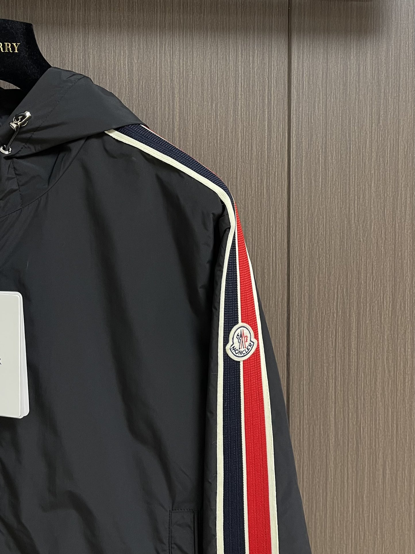 
Moncler 2025SS早秋侧边拼色织带设计连帽夹克外套，织物布面光洁细腻，呈现出细密的肌理和微光