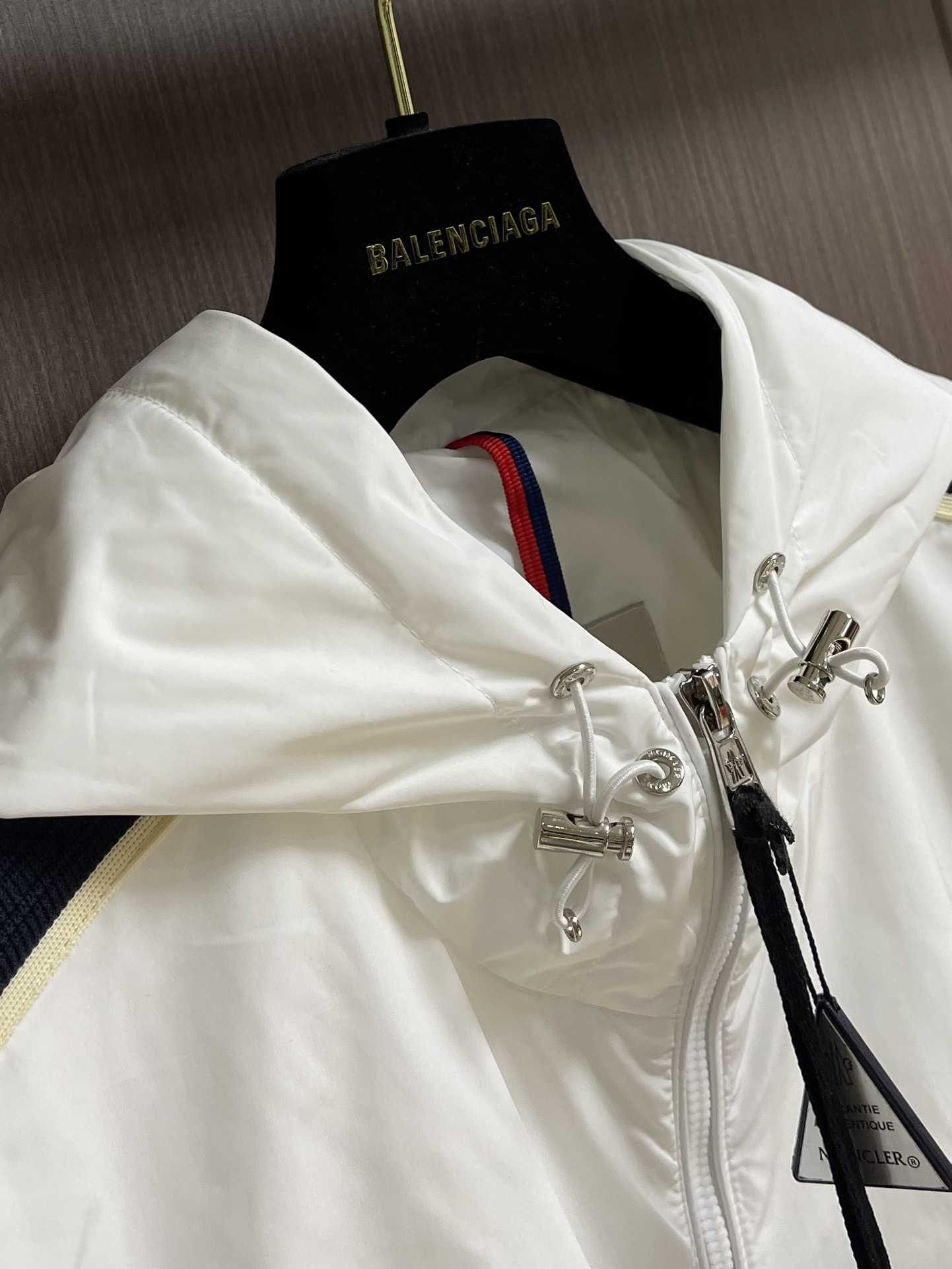 
Moncler 2025SS早秋侧边拼色织带设计连帽夹克外套，织物布面光洁细腻，呈现出细密的肌理和微光