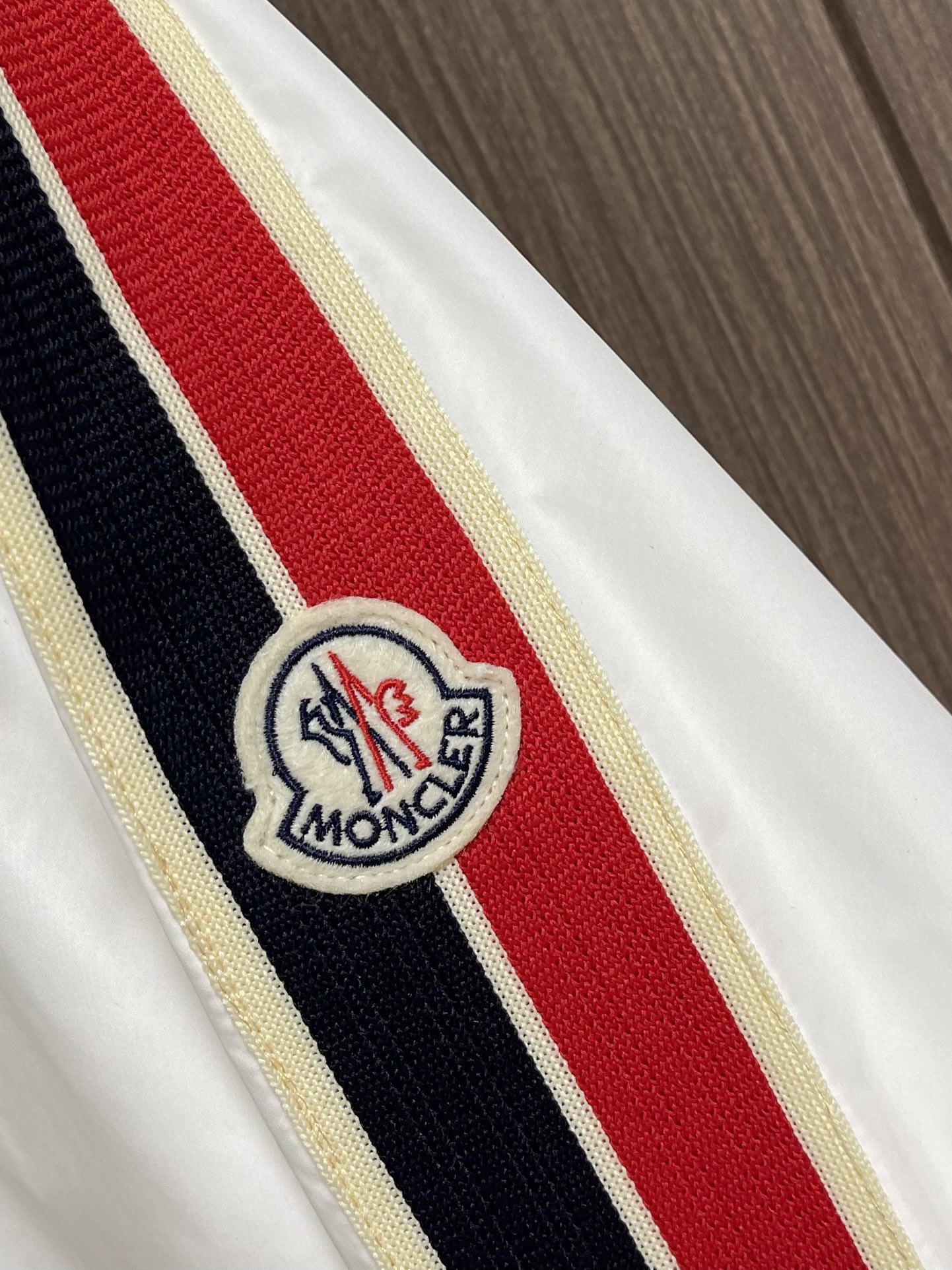 
Moncler 2025SS早秋侧边拼色织带设计连帽夹克外套，织物布面光洁细腻，呈现出细密的肌理和微光