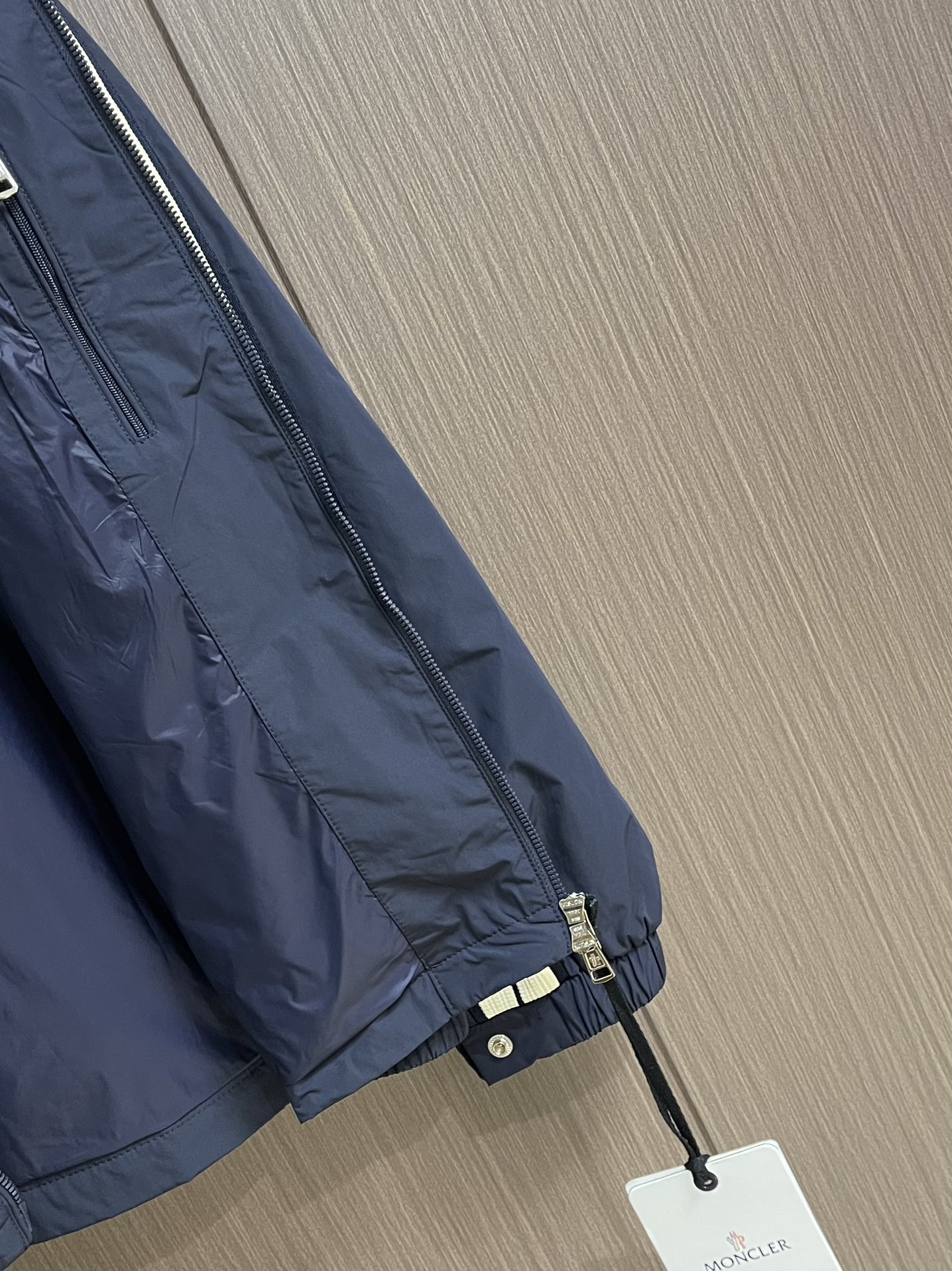 
Moncler 2025SS早秋侧边拼色织带设计连帽夹克外套，织物布面光洁细腻，呈现出细密的肌理和微光