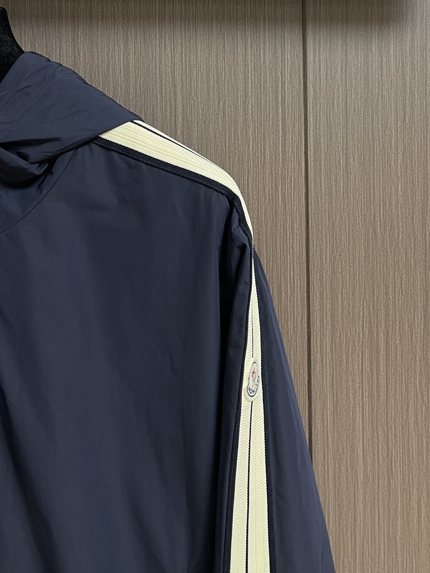 
Moncler 2025SS早秋侧边拼色织带设计连帽夹克外套，织物布面光洁细腻，呈现出细密的肌理和微光