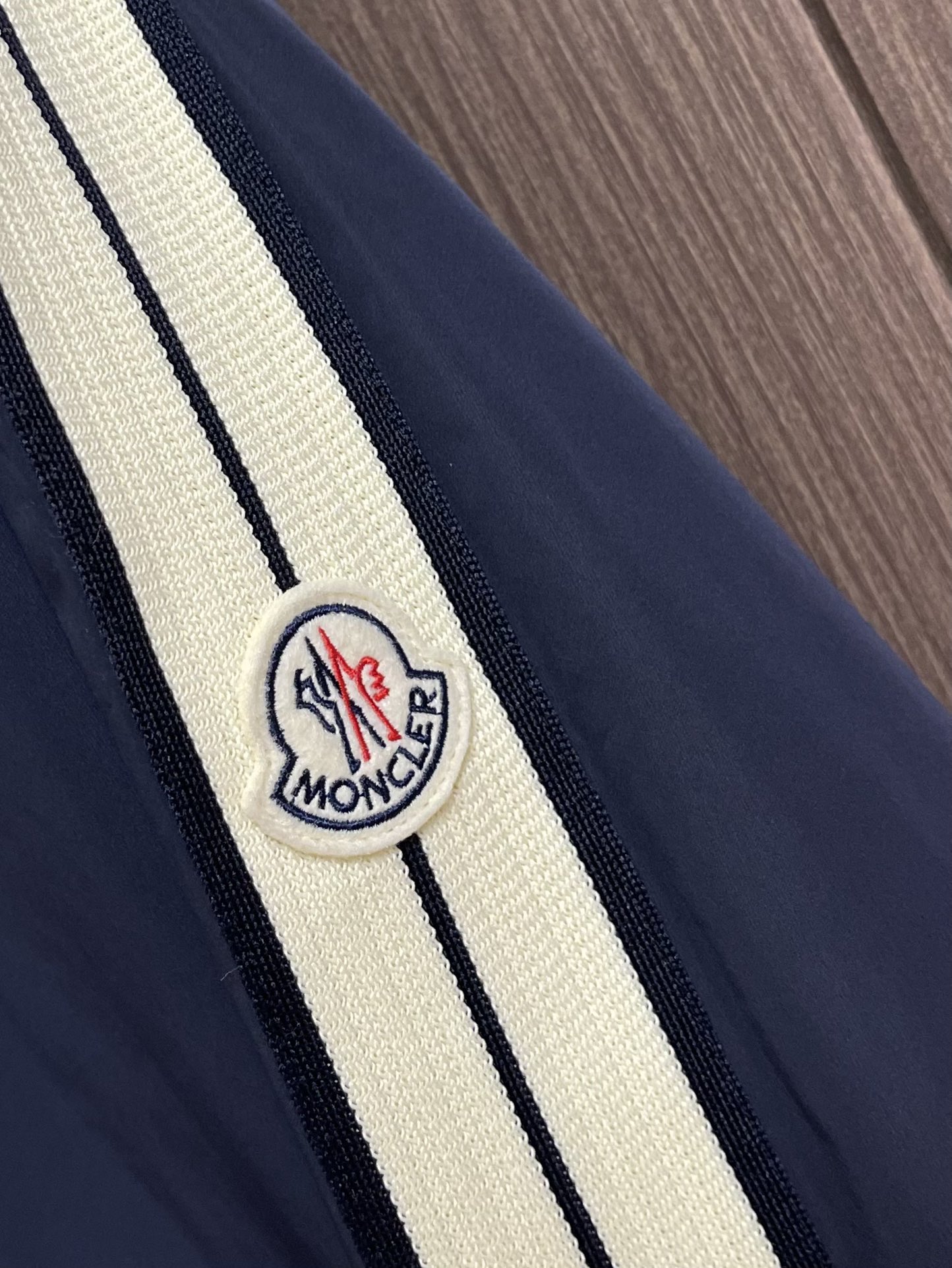 
Moncler 2025SS早秋侧边拼色织带设计连帽夹克外套，织物布面光洁细腻，呈现出细密的肌理和微光
