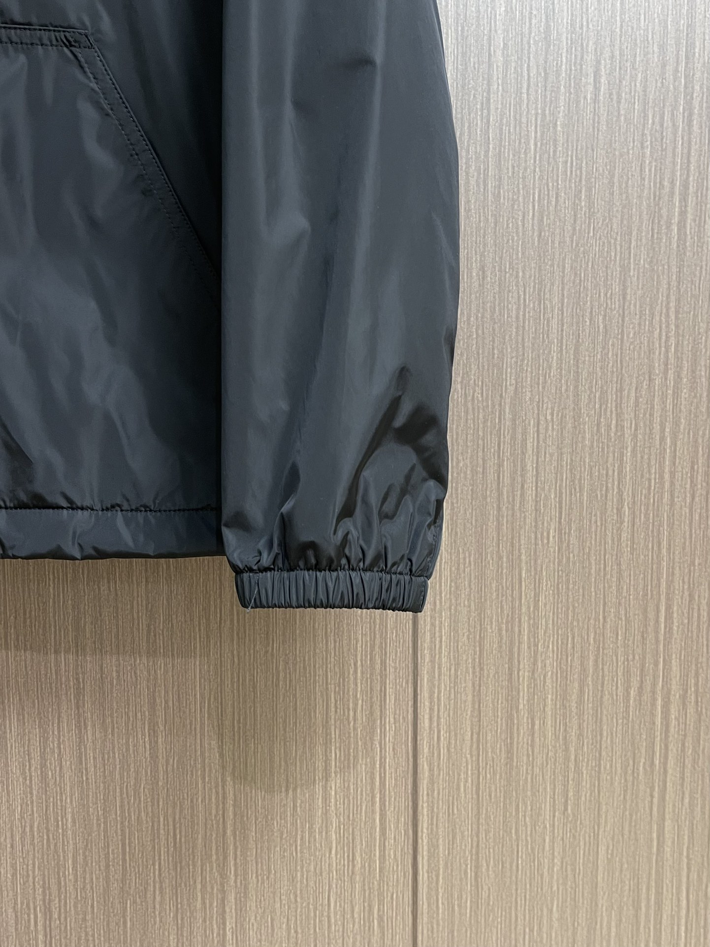 
PRADA 三角标再生尼龙外套，采用标志性的面料，是一种通过回收海洋中的塑料材料制成的再生尼龙织物体，