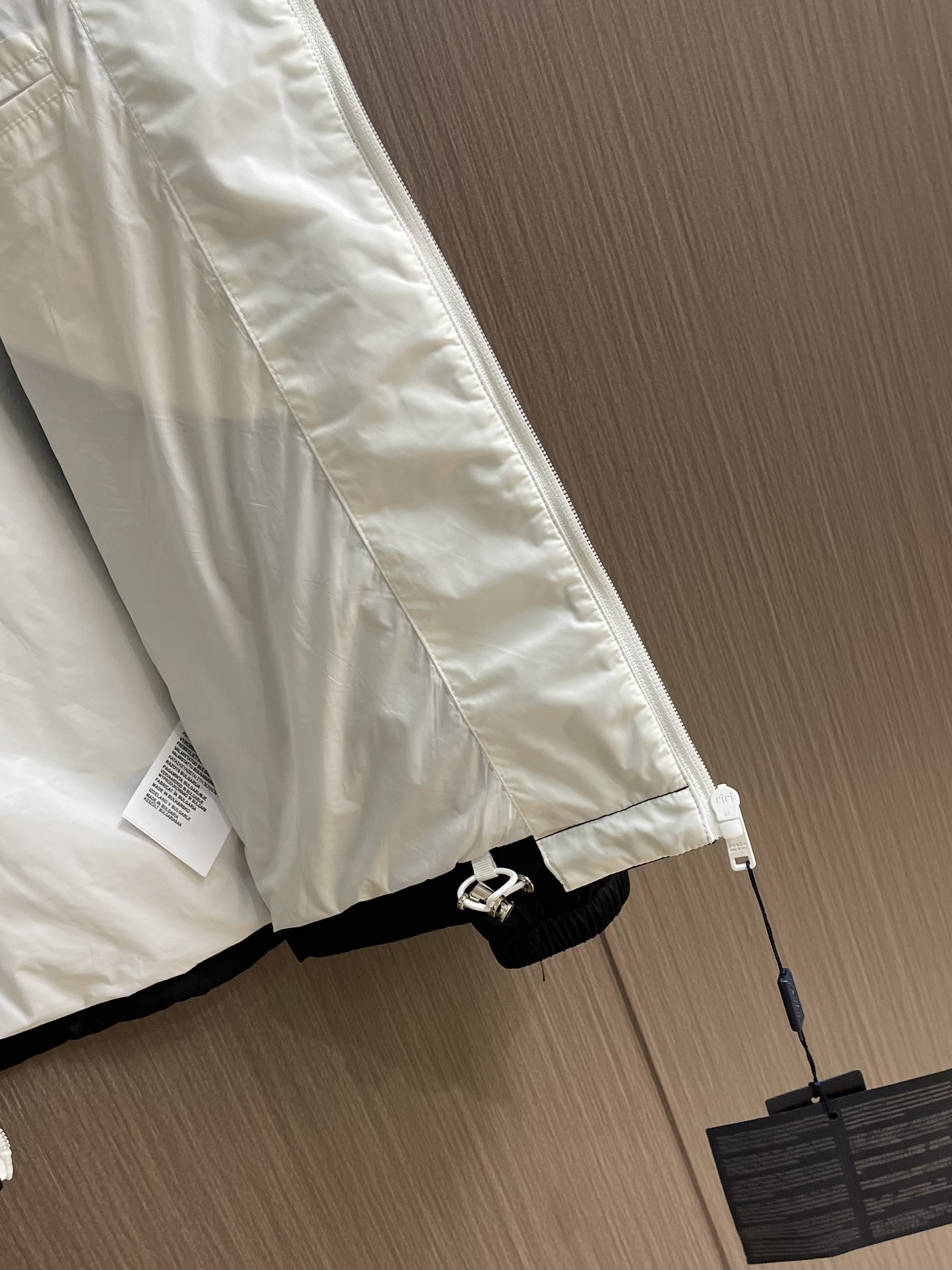 
PRADA 三角标再生尼龙外套，采用标志性的面料，是一种通过回收海洋中的塑料材料制成的再生尼龙织物体，