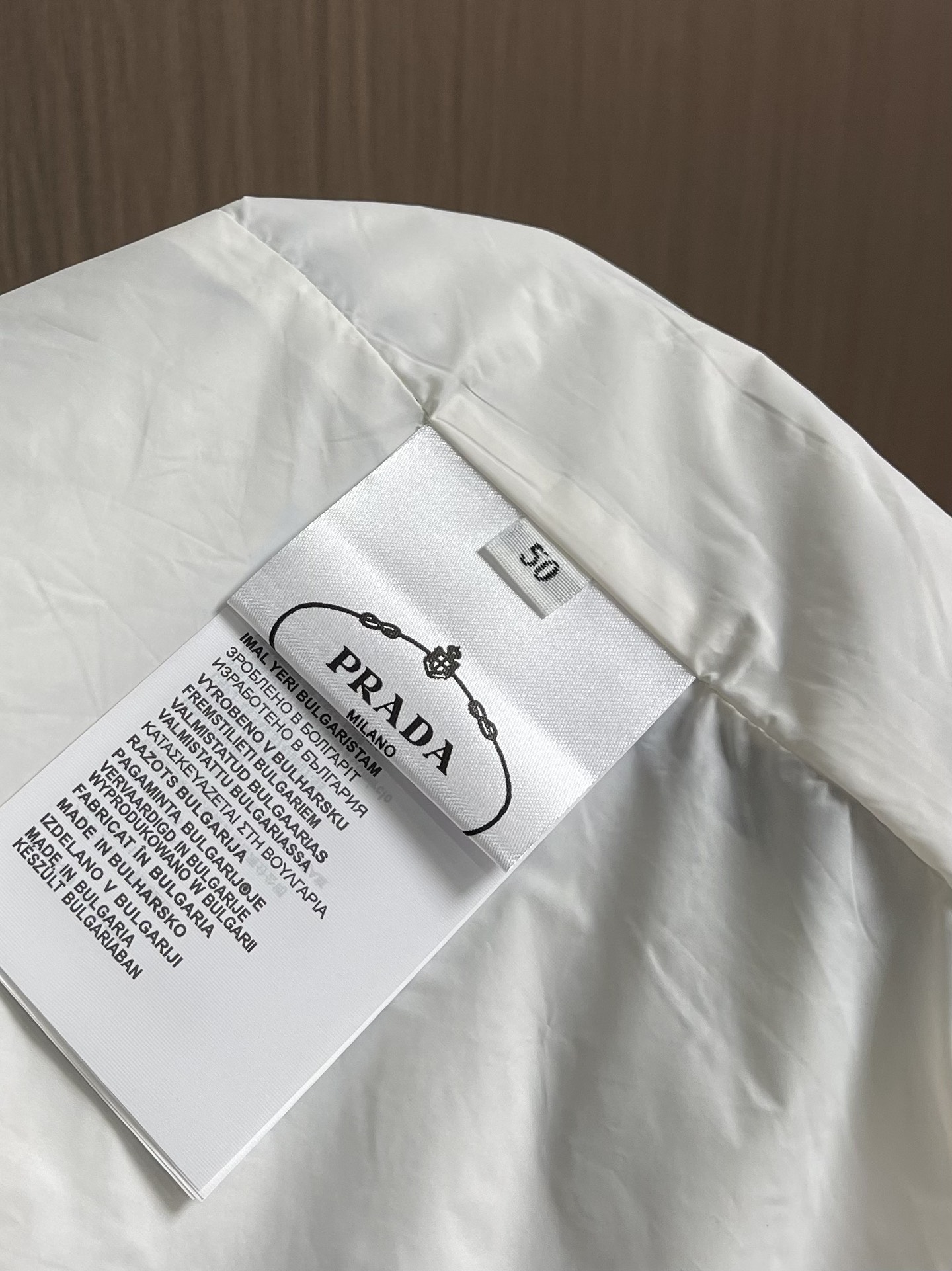 
PRADA 三角标再生尼龙外套，采用标志性的面料，是一种通过回收海洋中的塑料材料制成的再生尼龙织物体，