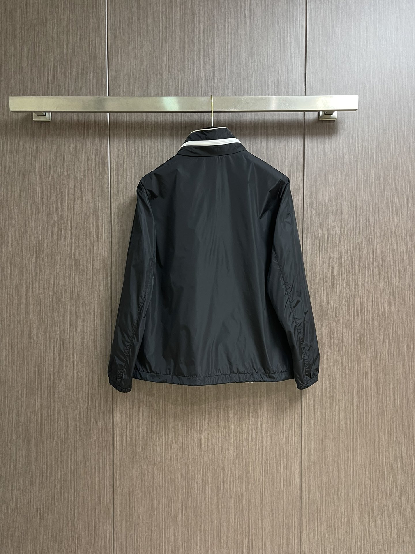 
PRADA 三角标再生尼龙外套，采用标志性的面料，是一种通过回收海洋中的塑料材料制成的再生尼龙织物体，