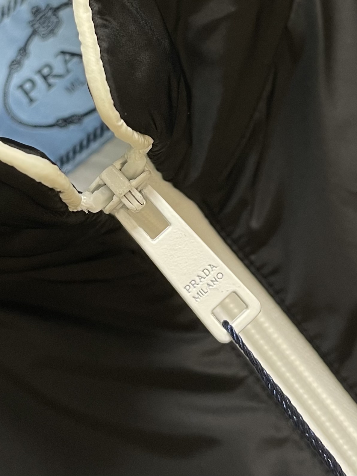 
PRADA 三角标再生尼龙外套，采用标志性的面料，是一种通过回收海洋中的塑料材料制成的再生尼龙织物体，