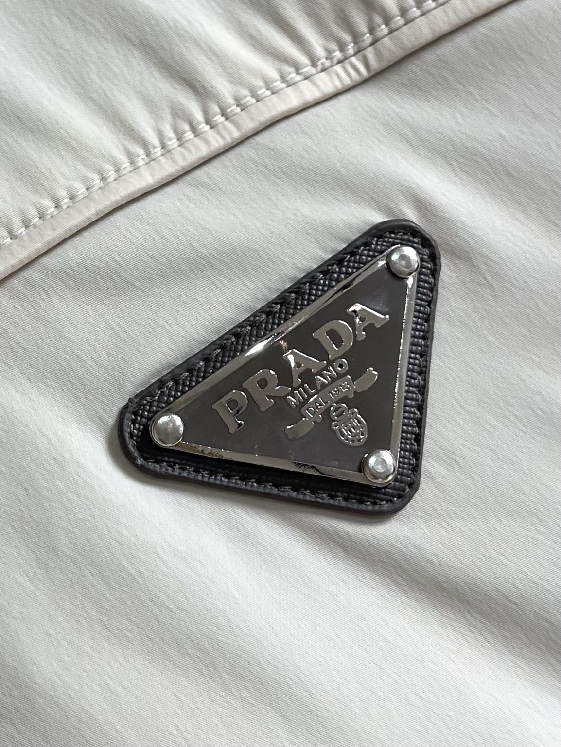 
Prada 2025SS秋季新款连帽夹克外套，胸前搭配标志性珐琅三角徽章标识，属于灵魂式点缀，夹克属于