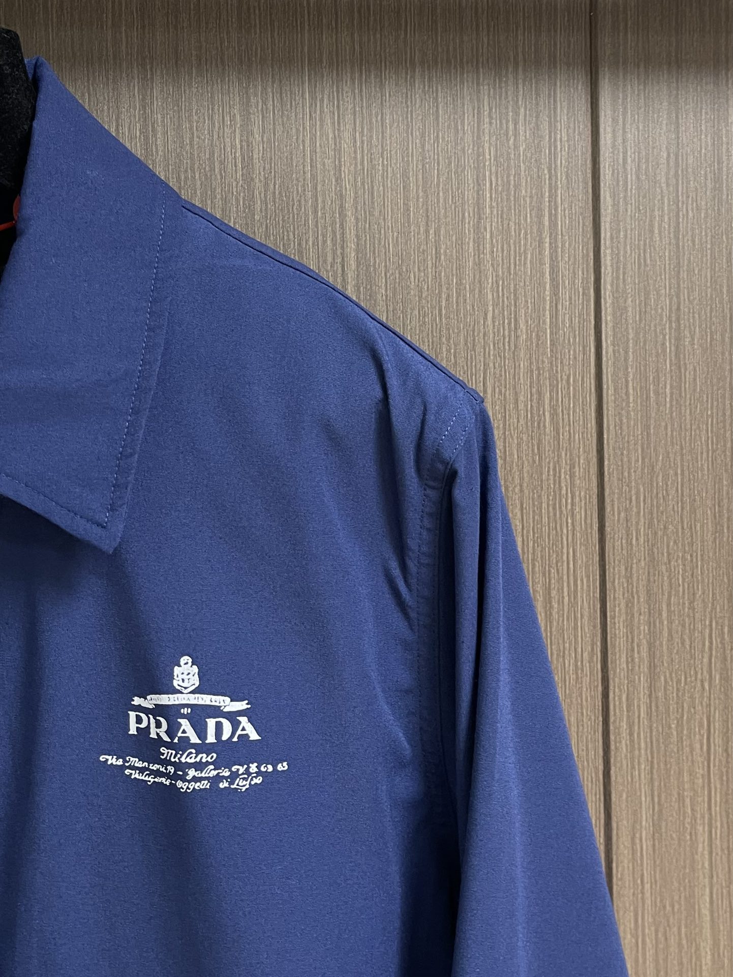 Prada 撞色印花徽标夹克外套 定制雅棉牛津纺 质感卓越 舒适贴肤 以一抹深邃蓝调为底 是沉淀后的优雅