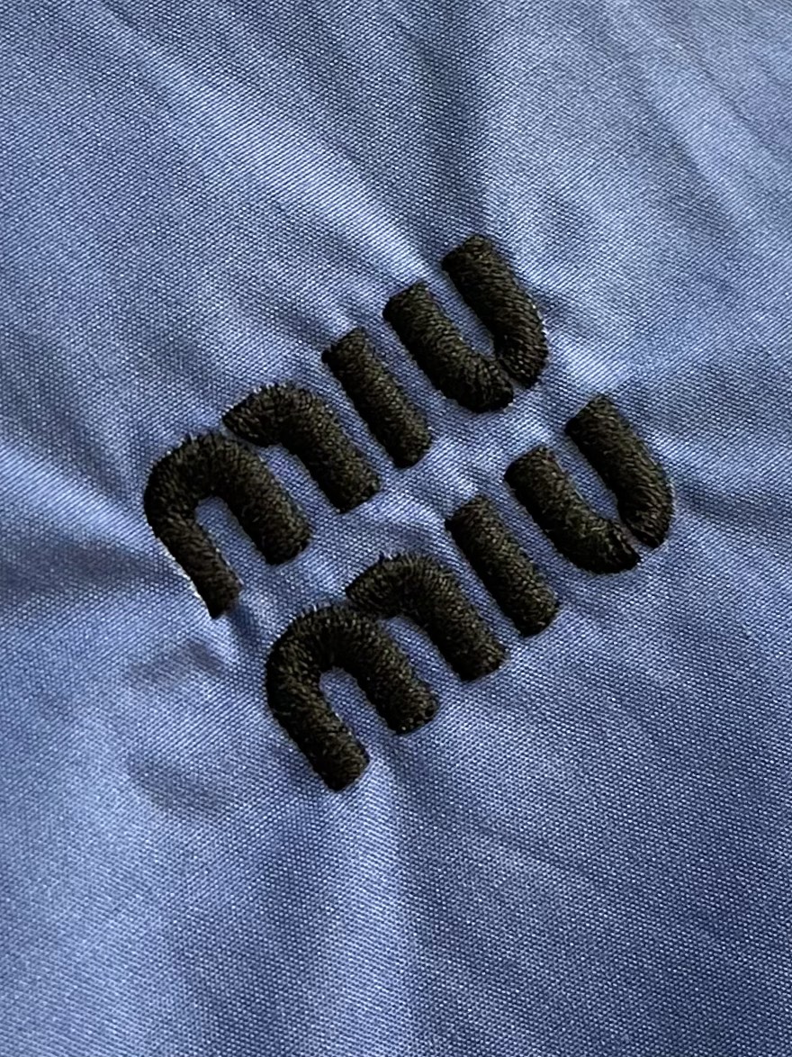 MiuMiu 徽标刺绣衬衫，定制天丝棉交织纱衬衫料 柔滑细腻 舒适贴肤 一抹靛蓝晕染在衬衫之上 高贵而优