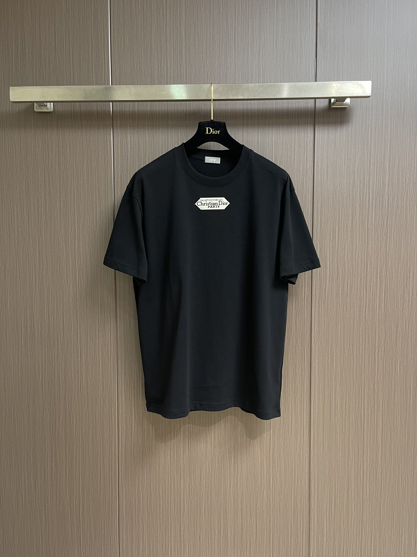 NO:531226,Dior small-label round neck short-sleeved T-shirt, cotton jersey fabric, chest with small labels, ribbed round neck and cuffs, conventional design, full set of auxiliary materials, cotton jersey fabric, 24S special-spun tight cotton fabric, 185g; matched with 32S double yarn thread, 300g. The tight spinning strength is higher than traditional single yarn, and the single fibers in the tight yarn are arranged tightly, which helps to improve the strength of the yarn. The ends of the fibers are twisted into the yarn, so the yarn is very tight, and the yarn looks smooth and there are fewer hair feathers. The tight spinning yarn has higher strength and fewer hair feathers, which is not easy to cause hair fur. The chest is decorated with a small label, and the 'Paris' on the label emphasizes the brand's French bloodline and fashion tradition; it is presented through the jacquard woven label process, reflecting the brand's pursuit of high-end craftsmanship and classic aesthetics. Through the digital jacquard loom  The brand text pattern is directly woven into the label, with clear texture and no burrs on the edges, which makes it more three-dimensional and durable than ordinary printed labels. High-string cotton material is used to ensure soft touch while maintaining a crispness; classic white black characters are interspersed, improving the texture through the luster of the yarn itself. The standard round neck style and the neckline are rounded curved, suitable for all face shapes and figures; the sleeves are moderate and just over the elbow, showing a capable and neat image. Slim-fitting cut can show the wearer's figure curve while not losing comfort. The neckline, cuffs, hem and other parts are sewn with fine double needle thread. Size XS-L,,dior,T-shirt,tees,t-shirt,alexander wang19860909Dior 小标签圆领短袖T恤,棉质平纹针织面料、胸前饰以小标签、罗纹圆领和袖口、常规版型设计、全套辅料,棉质平纹针织面料,采用24S特纺紧密棉面料,185g；搭配32S双纱螺纹,300g.紧密纺强力比传统单纱高,紧密纱中的单纤维排列紧密,有助于提高纱线的强力.纤维的端头均捻入纱线内,因此成纱非常紧密,纱线外观光洁毛羽少.紧密纺纱线强力较高毛羽较少,不易产生磨毛的现象.胸前饰以小标签,标签上的“Paris”强调品牌的法式血统与时装传统；通过提花织唛工艺呈现,体现了品牌对高级工艺与经典美学的追求.通过数码提花织机 将品牌文字图案直接织入标签,纹理清晰、边缘无毛刺,对比普通印刷标签更显立体感与耐久性.采用高支棉材质,确保柔软触感的同时保持挺括；经典白底黑字穿插,通过纱线本身的光泽提升质感.标准圆领版型,领口呈现圆润的弧形,适合各种脸型和身材；袖子适中刚好结束在肘部上方,展现出干练利落的形象.采用修身剪裁,能够展现出穿着者的身材曲线,同时不失舒适感.领口、袖口、下摆等部分都有精细双针走线的缝制.尺码XS-L,,dior,T-shirt,tees，t-shirt,alexander wang,Men's clothing