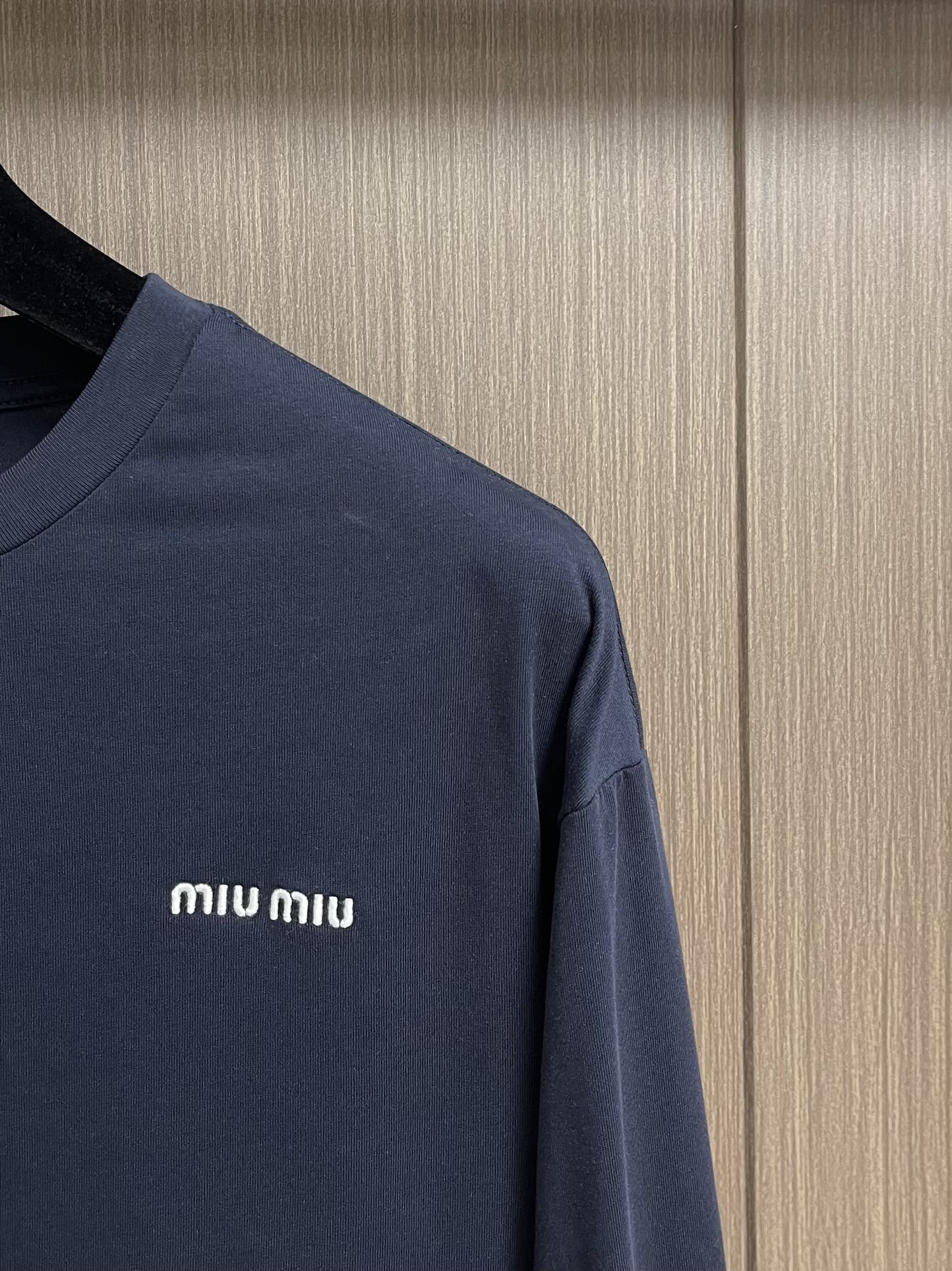 MIUMIU 2025SS圆领藏青色长袖T恤，采用高品级24支精梳棉纱线，通过「先染后织」工艺确保色彩均