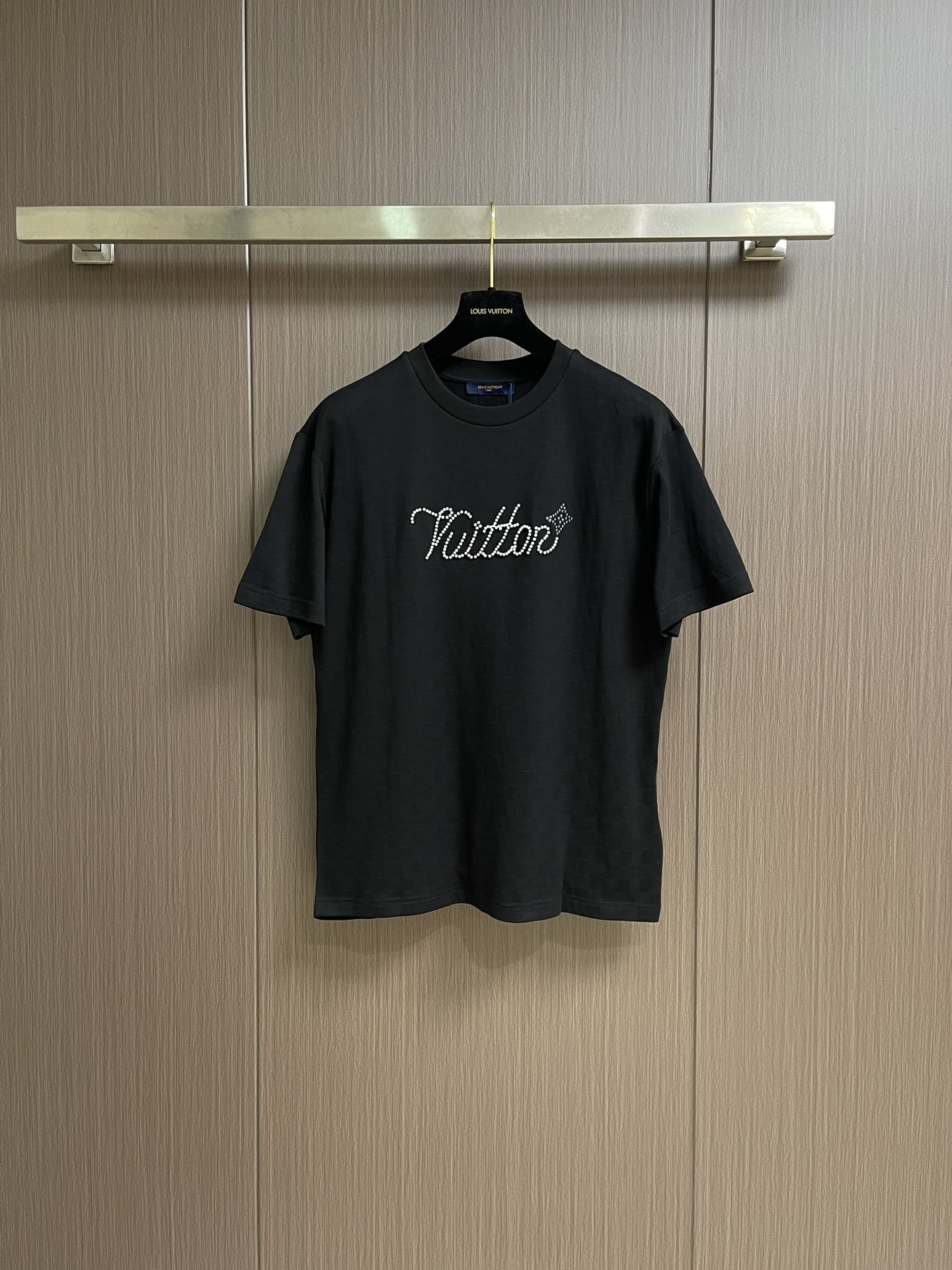 NO:528051,LV chessboard jacquard handwritten signature beaded beaded short-sleeved T-shirt, this beaded floor cotton presents a delicate texture with Der jacquard, and then beads on the chest with bright beads outlined handwritten Vuitton logo and  Flower pattern. Leather patches are placed behind. The surface of the beaded floor cloth is porous and has a similar shape to a honeycomb, which makes it more breathable and washable than ordinary knitted cloth. It not only has an elegant texture and luster, but also has a soft, smooth and textured feel. This special feel gives the fabric a high-quality touch, making the product more high-end. Combining resin beads with logo elements can create a suit that is both practical and artistic. The resin has the advantages of strong plasticity, high hardness, and good transparency; it makes this suit not only have a beautiful appearance, but also has certain practicality and personalization characteristics. Before the rivet printing begins, design the required printing patterns according to the pattern, and ensure that the pattern is simple and clear, and the number of particles is reduced. At the same time, consider the arrangement and fixing of the rivets to ensure its firmness and aesthetics. Size XS-L,,louis  vuitton, T-shirt,tees, t-shirt,alexander wang19860909LV 棋盘格提花手写签名串珠柳丁短袖T恤,本款珠地棉以Der提花呈现细腻肌理,再以莹亮串珠于胸前勾勒手写体 Vuitton标识和 Flower图案.皮革贴饰栖身背后.珠地布的表面是疏孔状的,形状与蜂巢相似,这使得它比普通针织布更透气耐洗.它不仅具有高雅的质感和光泽感,而且手感柔软、光滑、有质感,这种特殊的手感赋予了面料高品质的触感,使得产品更具高端感.将树脂珠饰与标识元素相结合,可以创造出既实用又具有艺术价值的装.树脂具有可塑性强、硬度高、透明度好等优点；使得这种装不仅具有美观的外观,还具有一定的实用性和个性化特点.铆钉印花开始制作前,根据版型设计好所需的印花图案,并确保图案简洁、明了,颗粒数还原.同时考虑铆钉的排列和固定方式,以确保其牢固性和美观性.尺码XS-L,,louis vuitton,T-shirt,tees，t-shirt,alexander wang,Men's clothing