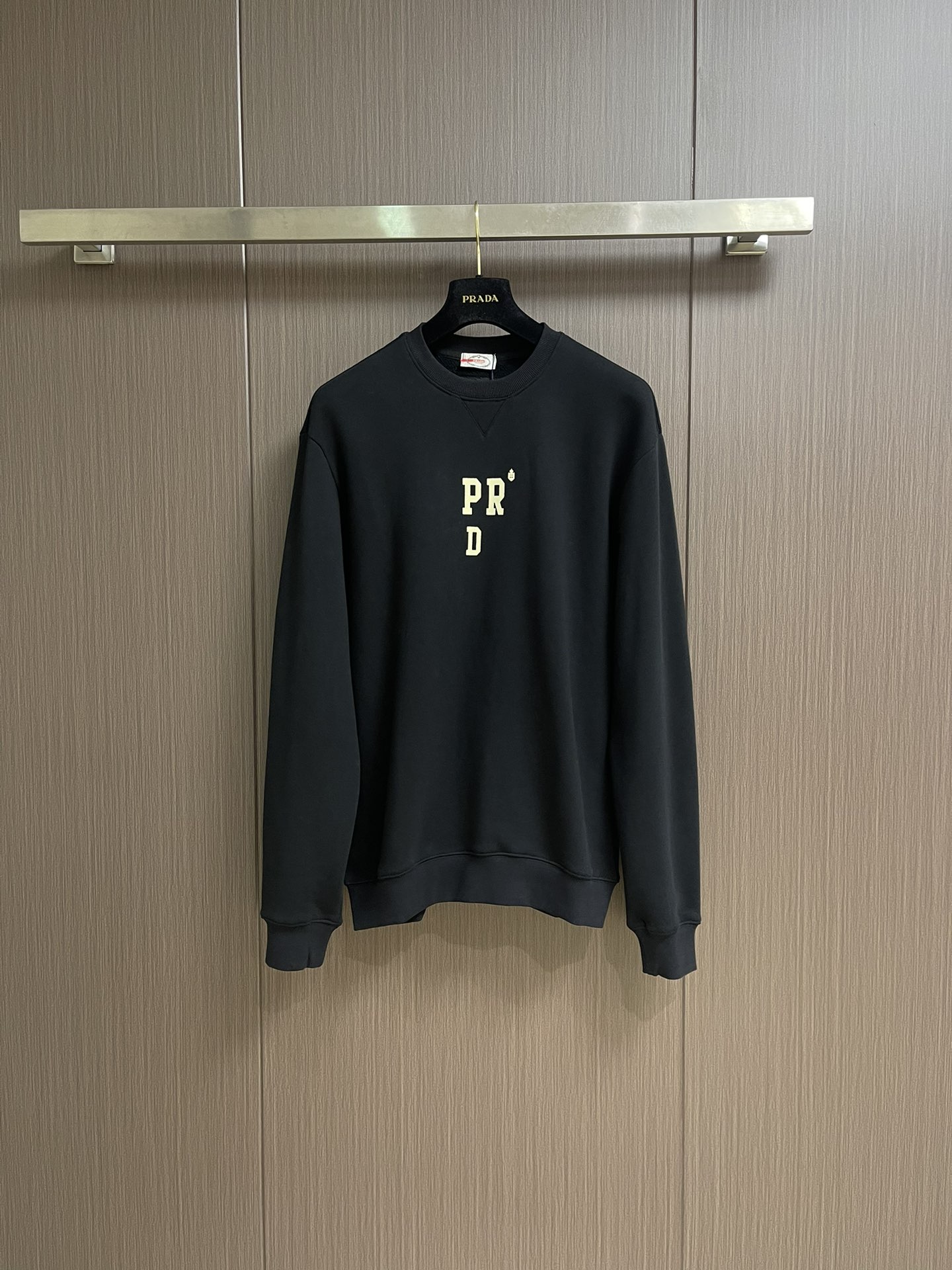 NO:573320,PRADA Abbreviated as letter 3D three-dimensional printed cotton round-neck sweatshirt, 32S reverse terry bottom yarn is interwoven, and its structure is tight and solid. The two yarns are plied to give the cloth surface a uniform and smooth texture; the reverse terry process forms rich and waxy velvet loops on the bottom surface, which greatly improves the softness, water absorption and warmth of the fabric. The overall is thick yet flexible. The combination of environmentally friendly thick plate printing and suede printing technology presents the dual qualities of three-dimensional fullness and fine soft velvet. Feel. Thick plate printing builds a strong and elastic 3D convex effect by scraping and printing thick glue multiple times. The graphic outline is tough, wear-resistant and washable. Suede printing uses the fine fiber fluff covered on the surface to present a soft and delicate velvet touch and matte high-end visual effect. Sizes M-XXL, prada, hoodie, sweatshirts, alexander wang19860909PRADA 简称字母3D立体印花棉质圆领卫衣,32S反向毛圈底纱交织,其结构紧密扎实,双纱合股赋予布面匀光洁的质感；反向毛圈工艺则于底面形成丰糯绒圈,极大提升了织物的柔软度、吸水性及保暖性能,整体厚实而不失柔韧.环保厚板印花与绒面印花工艺结合,呈现出立体饱满与细腻柔绒的双重质感.厚板印花通过多次刮印厚版胶浆,构筑起坚固且富有弹性的显著3D凸起效果,图形轮廓硬朗,耐磨耐洗.绒面印花则借助表面覆盖的细小纤维绒毛,呈现出柔软细腻的丝绒触感与哑光高级视觉效果.尺码M-XXL,,prada,hoodie,sweatshirts,alexander wang,Men's clothing