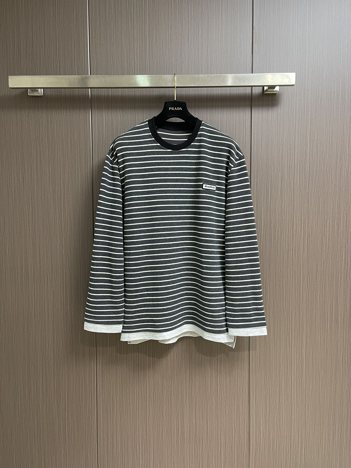 NO:529372,MiuMiu 2025SS logo logo striped long-sleeved T-shirt, 60 double-strand yarns are made of 60S 200G high-subscription combed cotton. The double-strand twisting process improves the strength of the yarn, making the fabric more delicate, crisp, wrinkle-resistant, while maintaining a soft and skin-friendly feel. The classic Jersey knitted structure provides good elasticity and drape, suitable for slim-fitting and textures on the front and back sides consistently, ensuring accurate stripe alignment. From the yarn ratio, density to gram weight, all are customized according to the original requirements to ensure color saturation and stripe clarity.  When cutting, the fabric strips must be strictly aligned at the front and rear pieces, armholes, side seams and other joints. The shoulder lines and sleeves are spliced ​​obliquely to reduce distortion; because of the extremely high requirements for grids, the fabric utilization rate may be as low as 60 (ordinary garments can reach 85), and the cost will increase significantly. Size S-XL, miumiu,tees, t-shirt, alexander wang19860909MiuMiu 2025SS 徽标logo条纹长袖T恤,定织60支双股纱线采用60S 200G高支数精梳棉,双股加捻工艺提升纱线强度,使面料更细腻、挺括、抗皱,同时保持柔软亲肤感. 平纹针织结构经典的Jersey针织提供良好的弹性和垂感,适合修身剪裁,且正反面纹理一致,确保条纹对位精准.从纱线配比、密度到克重均按原版要求定制,确保色彩饱和度和条纹清晰度. 裁片对位在裁剪时,需将面料条纹在前后片、袖窿、侧缝等接缝处严格对齐.肩线、袖笼采用斜裁拼接以减少扭曲；因对格要求极高,面料利用率可能低至60（普通成衣可达85),成本大幅上升.尺码S-XL,,miumiu,tees，t-shirt,alexander wang,Men's clothing
