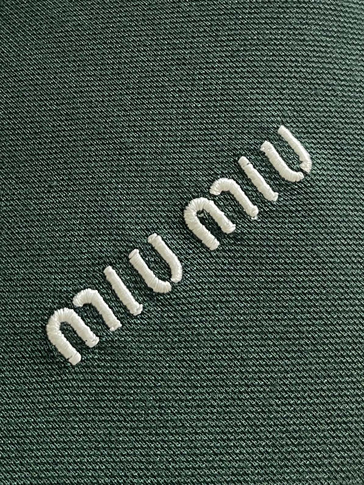MIUMIU 字母刺绣翻领长袖POLO，采用高品质珠地面料，其表面呈疏孔状，类似蜂巢，提供卓越的透气性和