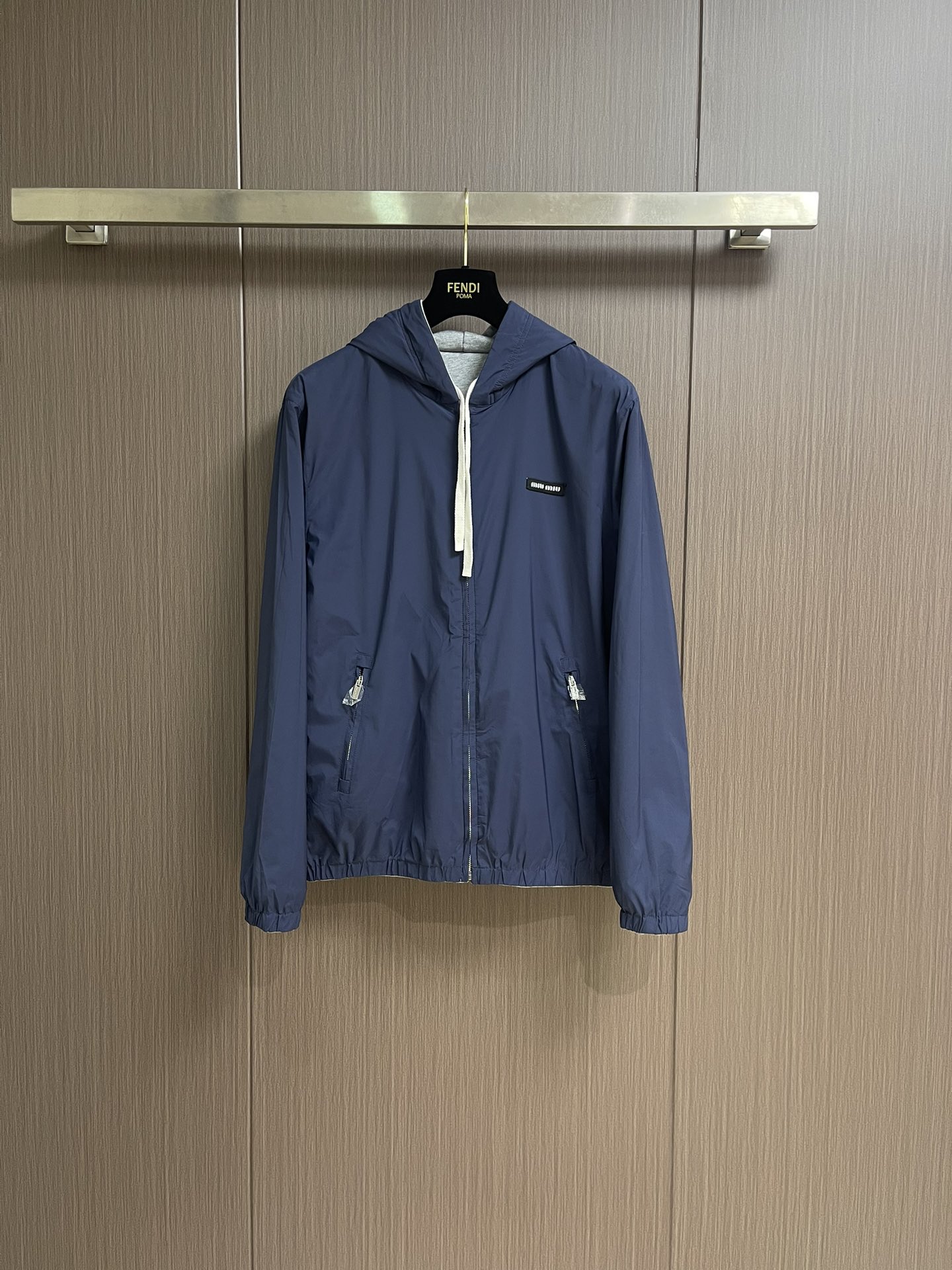 NO:527008,MIUMIU logo embroidered with double-sided hooded jacket jacket, functional poplin (Ponge) fabric is used, and the weaving method is high warp and low weft. The number of warp yarns per inch is much more than that of weft yarns. The surface is fine and uniform, diamond-shaped grain texture, which feels smooth and slightly shiny. The fiber characteristics make it natural moisture-absorbing and breathable, and it is not easy to stuffy. The high-density structure strengthens its wear resistance and has good wrinkle resistance. A single-sided fish scale fabric woven with cotton as a base has a smooth knitted surface on the front. The touching surface is formed by a three-dimensional loop through the floating thread knitting technology of the knitting machine, which increases the fluffy feeling and is also delicate. The loop structure absorbs a large amount of water and evaporates quickly, and it is not easy to deform after multiple washes.  By actively intervening in the shrinkage potential of cotton knitted surfaces, the fabric has been achieved from easy to change to stable, improving dimensional stability, and not easily deformed or wrinkled. The parts are wrapped with oblique cut cloth strips, and the width is controlled at about 0.4CM. The edges of the two layers of fabric are aligned and then folded and sewn, and the seams are hidden in the interlayer. Then they are fixed by 'anchoring points'. The inside and outside sides are formed without burrs, and all the seams are completely wrapped, while preventing the undesirable experience of easy sliding during wear. Size 46-52,,miumiu, jackets & coats, jackets & coats,hats,alexander wang19860909MIUMIU 徽标饰贴布绣双面穿连帽夹克外套,选用功能性的府绸（Ponge）面料,采用高经密,低纬密的织法,每英寸的经纱数量远多于纬纱,表面细密、均匀的菱形颗粒纹理,触感光滑且略带光泽感.纤维特性使其具有天然的吸湿透气,不易闷热.高密度的结构强化其耐磨性同时又具有良好的抗皱性.采用棉为基底编织而成的单面鱼鳞布面料,正面为平滑的针织面,触肤面通过针织机的浮线编织技术形成立体的毛圈,增加蓬松感, 同时触感细腻.毛圈结构吸水量大且蒸发快,多次洗涤不易松散变形. 通过主动干预棉针织面收缩潜能,实现了面料从易变到稳定的跨越,提升了尺寸稳定性,同时不易变形,褶皱.用斜裁布条包裹份,宽度控制在0.4CM左右.将两层面料边缘对齐后折叠缝合,缝线隐藏于夹层.再通过'锚定点'固定.形成内外两面均无毛边,所有缝份完全包裹,同时防止穿着中易滑动的不良体验.尺码46-52,,miumiu,jackets & coats,jackets & coats,hats,alexander wang,Men's clothing