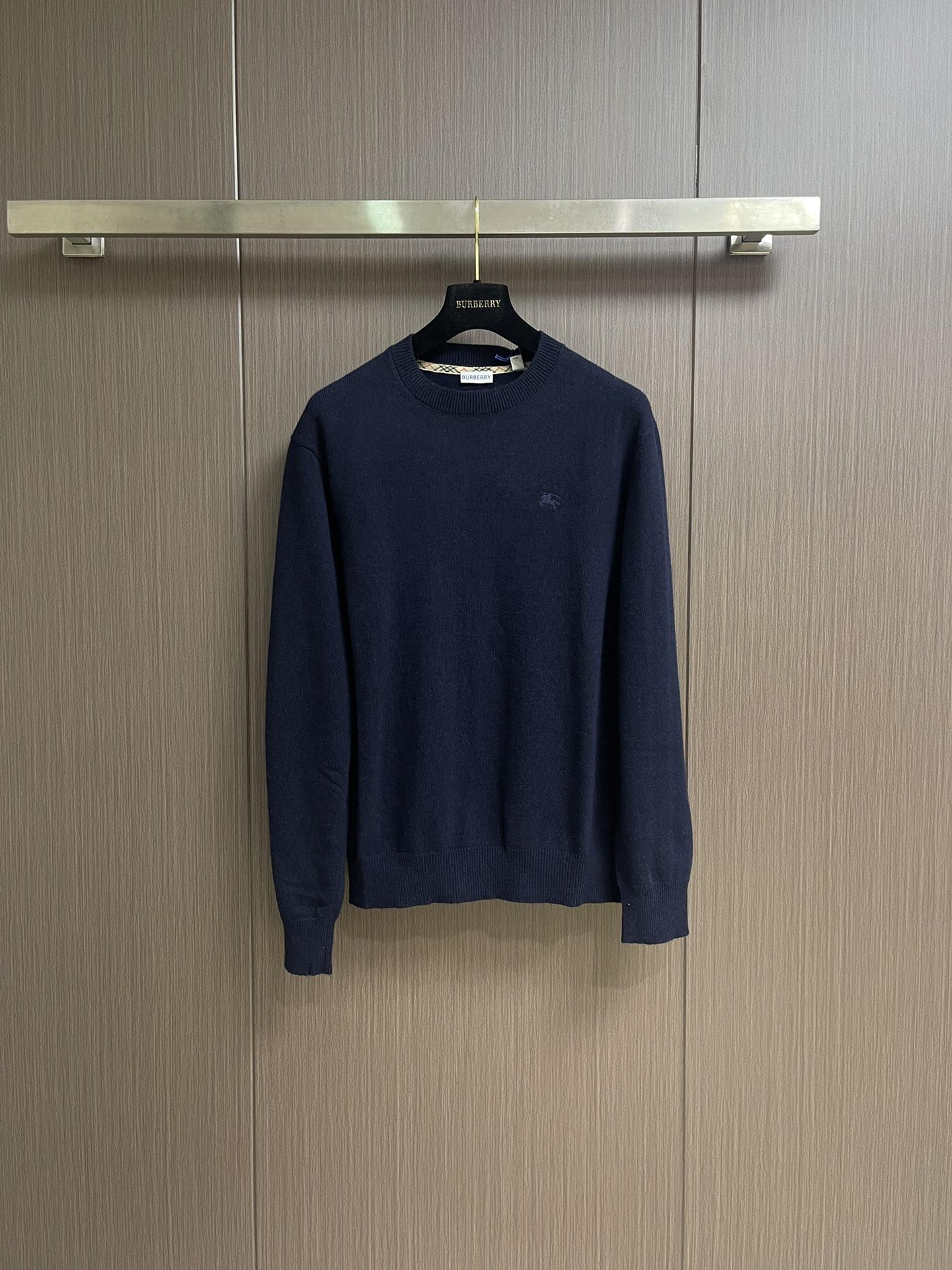 NO:527002,Burberry  The war horse embroidered round-neck knitted sweater is made of cashmere as the main body and provides an unparalleled wearing experience. The feeding of a small amount of polyamide and lycra enhances the overall durability and pill resistance, and woven into the soft cashmere into an invisible support network, which also has a certain elasticity, better fits the human body curve and is retractable. The ribbed decorative parts of the neckline and cuffs are made of blended fabrics, which further enhances the texture and wearing experience. Due to the characteristics of the sweater fabric, the frame is stretched just right, and then a hot melt pad is used under the wool sheet to provide it with a certain temporary and stable support to prevent the pattern from being twisted, wrinkled and stitched. The computer embroidery machine's high-precision calculation program  The system controls the embroidery frame to move in the XY direction, and at the same time, the needle is shuttled up and down, and embroidered according to the set path, automatically completes the movements of thread cutting and jumping, forming a stitch track, and automatically adjusts the tension of the upper and lower lines to ensure that the stitch is flat and there is no floating line, forming a war horse pattern with an error of ±0.1mm. Add detergent and initially rinse the large goods at a water temperature of about 35 degrees to remove impurities in the production process, and then gently digest the feathers on the surface through protease, reduce the pilling tilt from the root, improves the feel, retains the softness, and eliminates the stimulation. Finally, after dehydration and drying, the size and shape stability are improved. Size S-XL, burberry, sweaters, alexander  wang19860909Burberry 战马饰刺绣圆领针织毛衣,以羊绒为主体主导面料的手感、保暖性和轻盈感,同时提供无与伦比的穿着体验.少量聚酰胺和莱卡的喂入增强整体的耐用性和抗起球性,在柔软的羊绒中编织进了一个无形的支撑网络,同时又有一定的弹力,更好的贴合人体曲线,收放自如.领口和袖口罗纹装饰部件选用同比例混纺面料,进一步提升了质感与穿着体验.因毛衣面料特性,绷框时拉伸恰到好处,再使用热熔衬垫在毛织片下方,为其提供一定的临时稳定支撑,防止取下后回缩导致图案扭曲,起皱和针迹凹陷.电脑绣花机高精度的计算程序系统控制绣花框在XY方向移动,同时机针上下穿梭,按照设定的路径进行刺绣,自动完成剪线、跳线等动作,形成针迹轨迹,自动调整上线和下线张力,确保线迹平整无浮线,形成误差在±0.1mm的战马图案.加入洗涤剂,将大货在约35度的水温下进行初步漂洗,去除生产过程中的杂质,再通过蛋白酶温和的消化掉表面的毛羽,从根源上减少起球倾,改善手感,保留柔软度,消除刺激感.最后通过脱水和烘干处理之后,提升尺寸和形状稳定性.尺码S-XL,,burberry,sweaters,alexander wang,Men's clothing