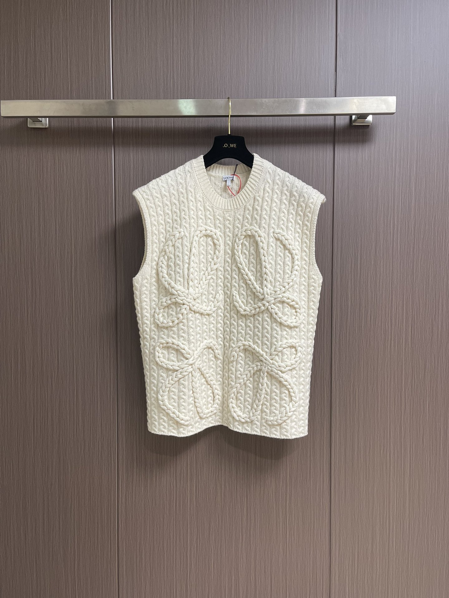 NO:530145,Loewe Anagram Twist woven sleeveless vest sweater, fixed knit heavy mercerated wool embossed knitted wool material, full texture, heavy and solid, with black as the background, hand-cranked special machine embossing craftsman manual control of customized special knitting machines, human-machine collaborative knitting logic, real-time adjustment of yarn tension to control the rise and fall of knitting needles, forming a Loewe Anagram flower pattern with three-dimensional concave and convex texture, full-region twist rope composite double process, symphonic weaving of hand and machinery, the whole piece of clothing uses twist rope + webbing composite weaving, line by line, manual connection, 3 steps to wrap twist ropes, one webbing, one stitch, and one stitch, and a stitch, and a cumulative 200-300 rows (time and labor-intensive, expensive)  Size S-XL, loewe, loewe, sweaters, alexander wang19860909Loewe 罗意威 Anagram 麻花编织无袖马甲毛衣,定织重磅丝光羊毛浮雕针织毛料 质感十足 厚重扎实 以玄黑为底色 手摇专机浮雕花型工艺 通过匠人手工操控定制化专用编织机 人机协同的编织逻辑 实时调整纱线张力控制织针起落 形成具有立体凹凸肌理的Loewe Anagram花型图案 全域扭绳复合双工艺 手工与机械的交响织艺 整件服饰均采用扭绳＋织带复合编织 逐行手工衔接 每编织1行需完成扭绳缠绕一织带穿插一针床复位3个步骤 编织一件成衣需累计200-300行（耗时耗力 工价昂贵） 尺码S-XL,,loewe,loewe,sweaters,alexander wang,Men's clothing