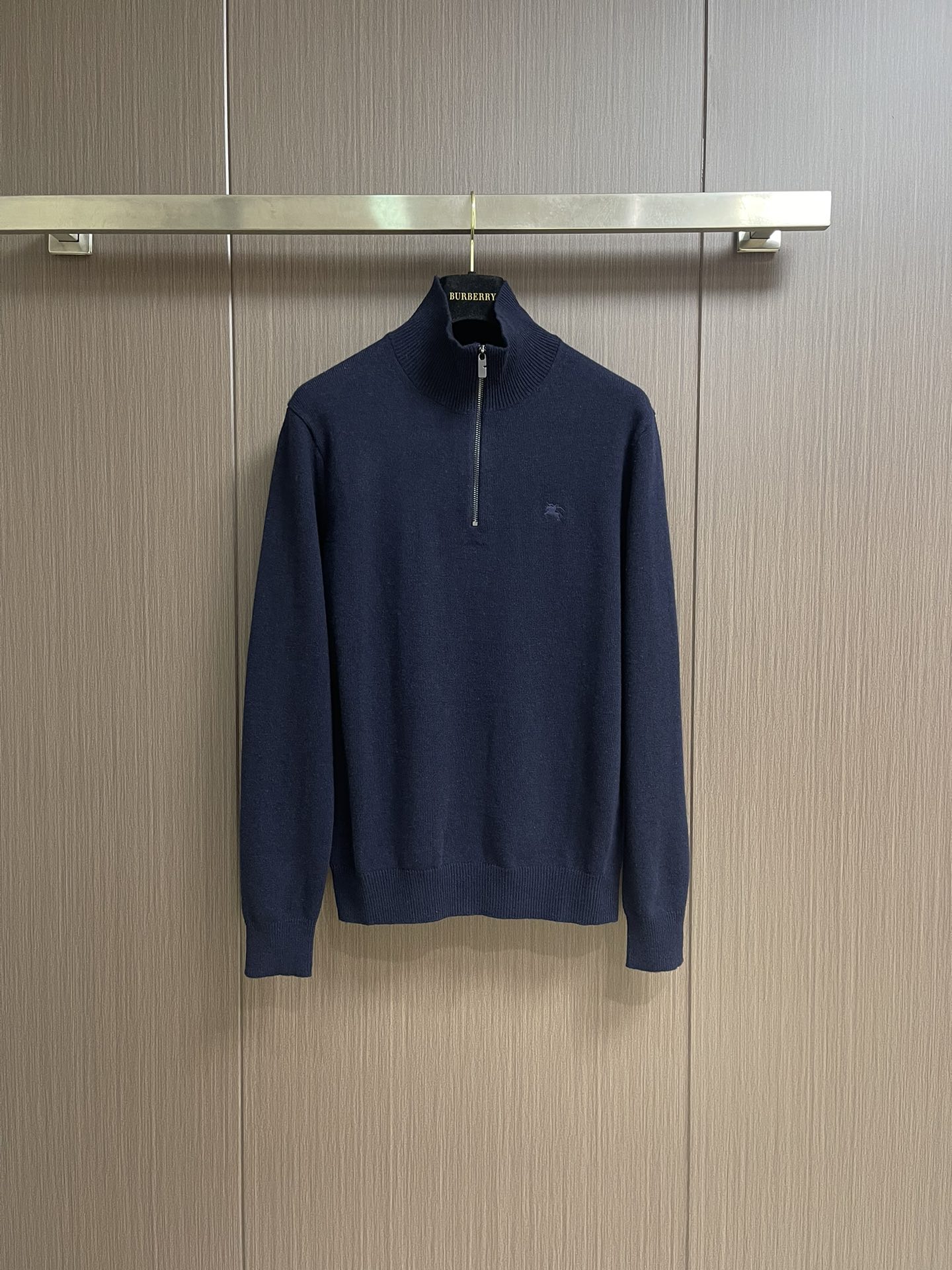 NO:538708,Burberry war horse embroidered semi-zipper turtleneck knit sweater, with cashmere as the main body leading the feel, warmth and lightness of the fabric, while providing an unparalleled wearing experience. The feeding of a small amount of polyamide and lycra enhances the overall durability and anti-pilling properties, and woven into an invisible support network in the soft cashmere, while having a certain elasticity, better fits the human body curve and allows for easy retention.  Due to the characteristics of the sweater fabric, the frame is stretched just right when stretching, and then a hot melt pad is used under the wool sheet to provide it with certain temporary stable support to prevent the pattern from being twisted, wrinkled and stitched after removal. The computer embroidery machine's high-precision calculation program system controls the embroidery frame to move in the XY direction. At the same time, the needle is shuttled up and down, and embroidered according to the set path, automatically completing the cutting and jumping actions, forming a stitch track, and automatically adjusting the tension of the upper and lower lines to ensure that the stitch is flat and there is no floating line.  Form a war horse pattern with an error of ±0.1mm. Add detergent and perform preliminary rinsing at a water temperature of about 35 degrees to remove impurities in the production process. Then gently digest the feathers on the surface through protease, reduce the tendency to pill from the root, improve the feel, retain softness, and eliminate irritation. Finally, after dehydration and drying, the size and shape stability are improved. Size S-XL, burberry, sweaters, alexander  wang19860909Burberry 战马刺绣半拉链高领针织毛衣,以羊绒为主体主导面料的手感、保暖性和轻盈感,同时提供无与伦比的穿着体验.少量聚酰胺和莱卡的喂入增强整体的耐用性和抗起球性,在柔软的羊绒中编织进了一个无形的支撑网络,同时又有一定的弹力,更好的贴合人体曲线,收放自如. 因毛衣面料特性,绷框时拉伸恰到好处,再使用热熔衬垫在毛织片下方,为其提供一定的临时稳定支撑,防止取下后回缩导致图案扭曲,起皱和针迹凹陷.电脑绣花机高精度的计算程序系统控制绣花框在XY方向移动,同时机针上下穿梭,按照设定的路径进行刺绣,自动完成剪线、跳线等动作,形成针迹轨迹,自动调整上线和下线张力,确保线迹平整无浮线,形成误差在±0.1mm的战马图案.加入洗涤剂,将大货在约35度的水温下进行初步漂洗,去除生产过程中的杂质,再通过蛋白酶温和的消化掉表面的毛羽,从根源上减少起球倾向,改善手感,保留柔软度,消除刺激感.最后通过脱水和烘干处理之后,提升尺寸和形状稳定性.尺码S-XL,,burberry,sweaters,alexander wang,Men's clothing