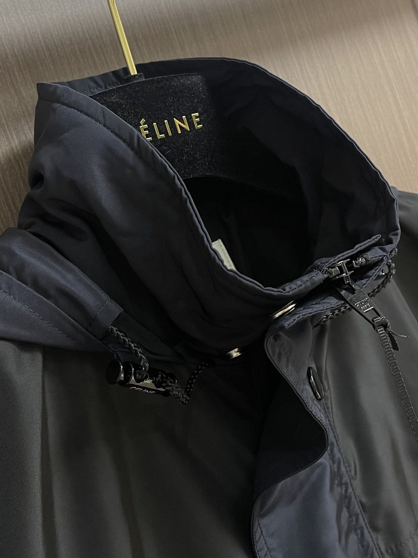 Celine 饰刺绣连帽风衣外套，选用100％聚酯纤维打造而成的牛津布面料。纤维特性具有良好的韧性，加上