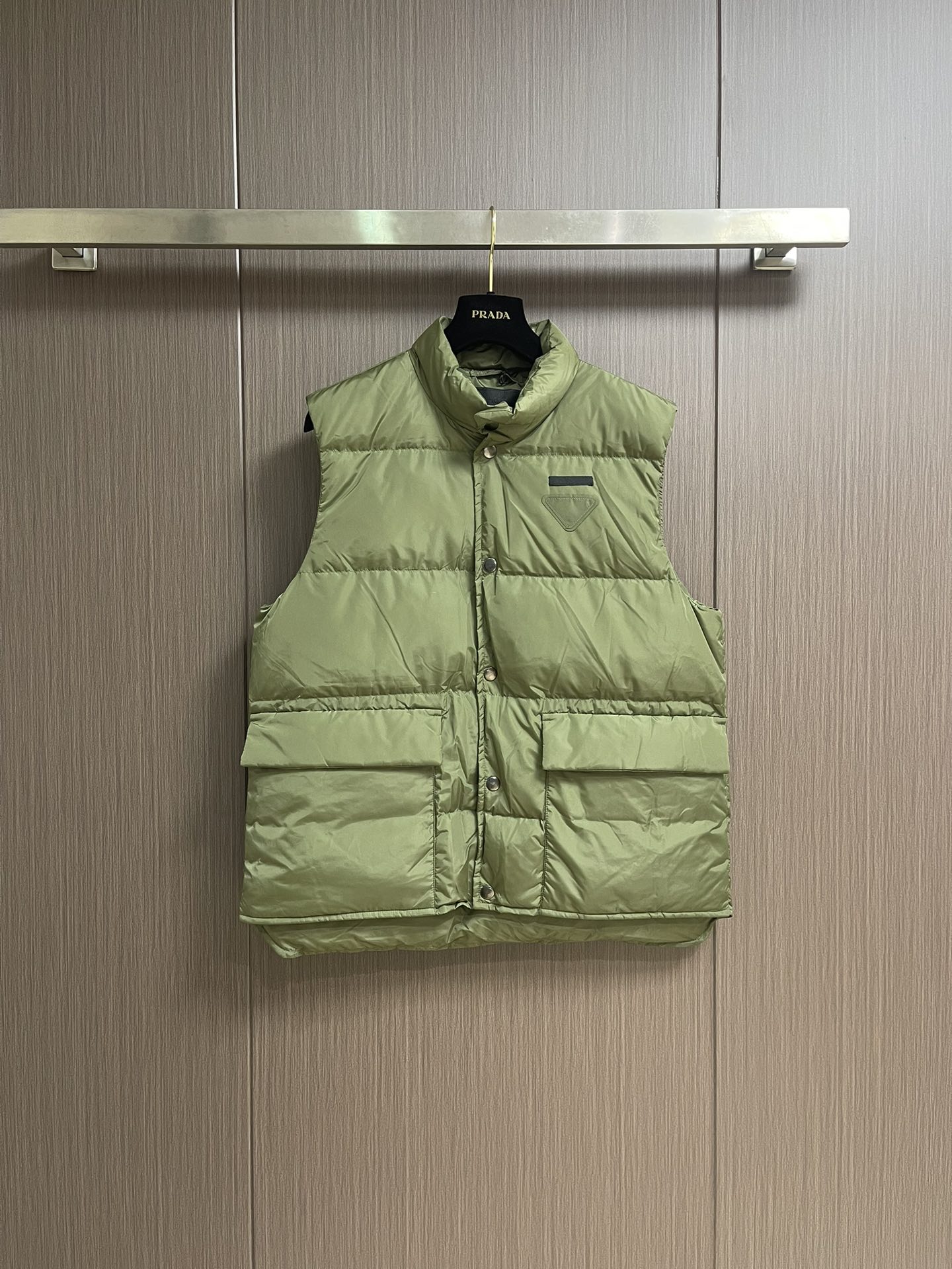 Prada 饰织物三角标羽绒马甲，选品牌标志性的再生尼龙面料，与传统尼龙性能相当，具备高强度，抗撕裂，耐