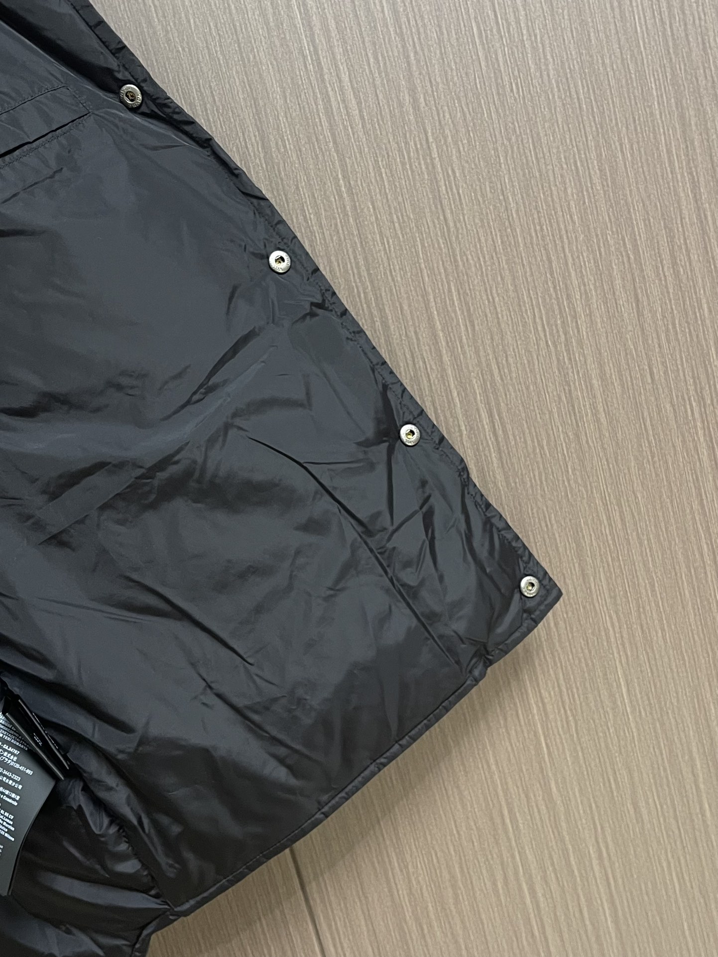 Prada 饰织物三角标羽绒马甲，选品牌标志性的再生尼龙面料，与传统尼龙性能相当，具备高强度，抗撕裂，耐