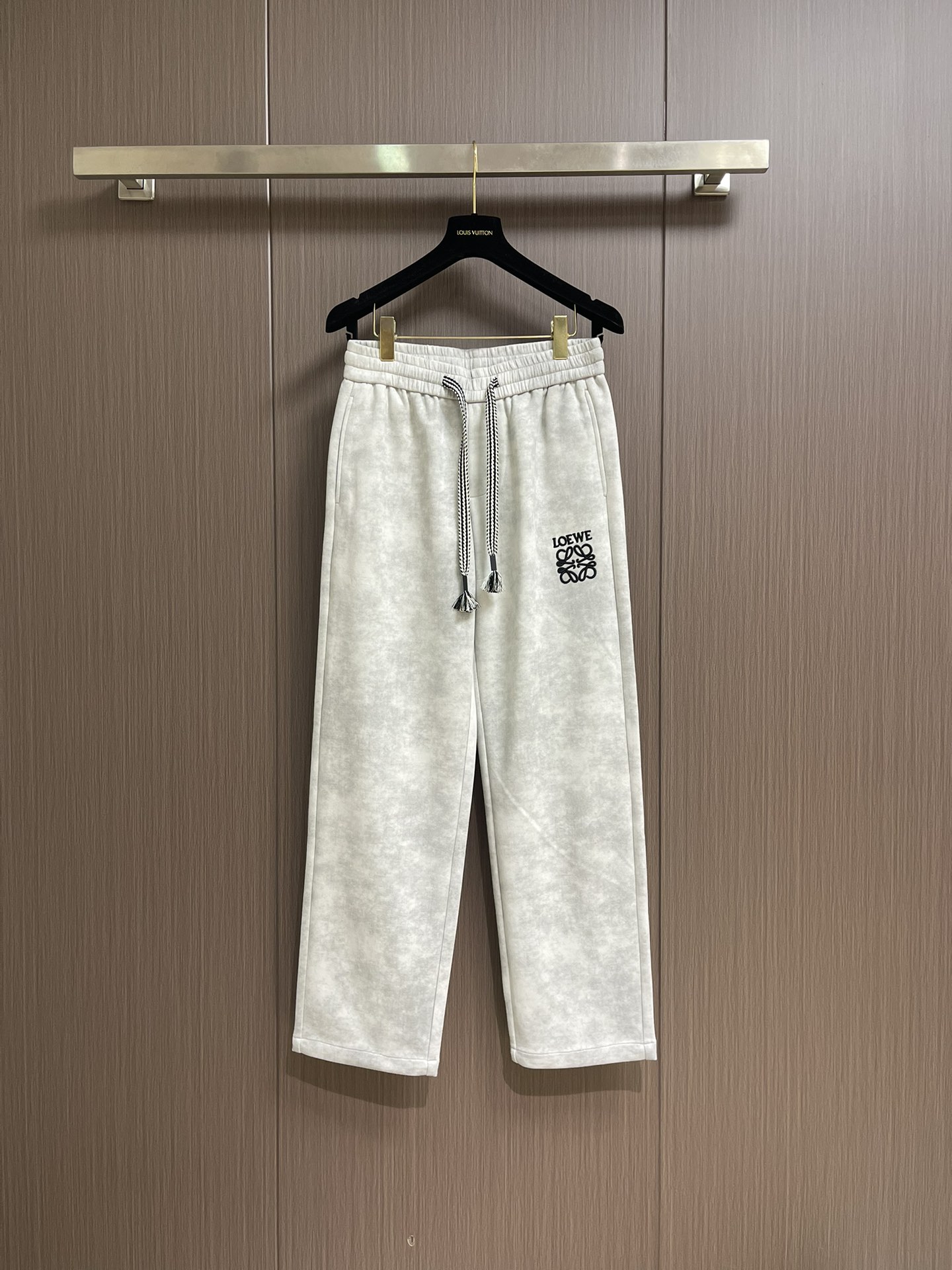 NO:546978,LOEWE LOEWE embroidered straight trousers, the weight is about 420 grams after washing the laundry, the texture is thick, crisp, wear-resistant and retro flavor; the 3D three-dimensional embroidery process is amazing, the number of double-sided embroidery needles reaches about 1 stitch, the needle method is delicate, the brand logo is three-dimensional and full, highlighting the exquisiteness and high-end sense; the sand washing gives the fabric a unique texture and soft feel, and the stir-fry color accurately controls the color, making the fading natural and layered; the old treatment is like carving for years, with a rich retro style, and each pair of pants has a unique personality, which is a masterpiece that perfectly integrates fashion and craftsmanship. Size M-3XL,,loewe,loewe,alexander wang19860909LOEWE 罗意威刺绣直筒长裤,成衣洗水后克重约420克,质感厚实挺括耐磨且具复古韵味；3D立体刺绣工艺令人赞叹,双边刺绣针数约达1针,针法细腻,品牌标识立体饱满,凸显精致与高级感；沙洗赋予面料独特纹理与柔软手感,炒色精准把控色彩,使褪色自然且富有层次感；做旧处理仿若岁月雕琢,复古风格浓郁,每条裤都独具个性,是时尚与工艺完美融合的佳作.尺码M-3XL,,loewe,loewe,alexander wang,Men's clothing