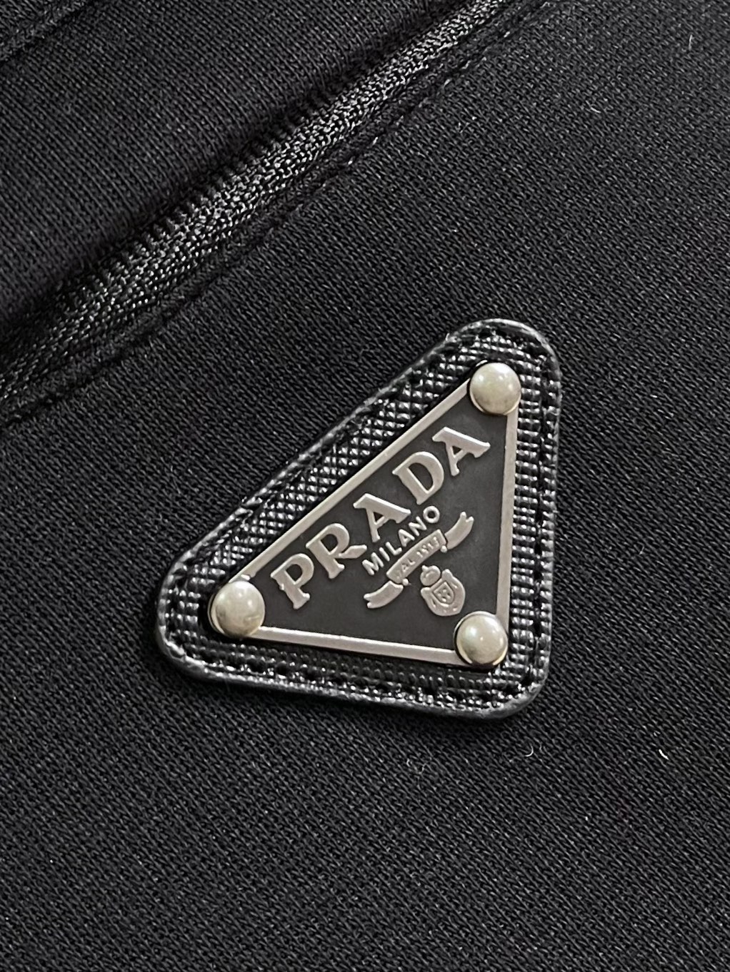 Prada 尼龙丝光拼接罗马面料拉链外套，采用380克丝光双面，该款面料偏柔软，密度高，高密度面料可有效