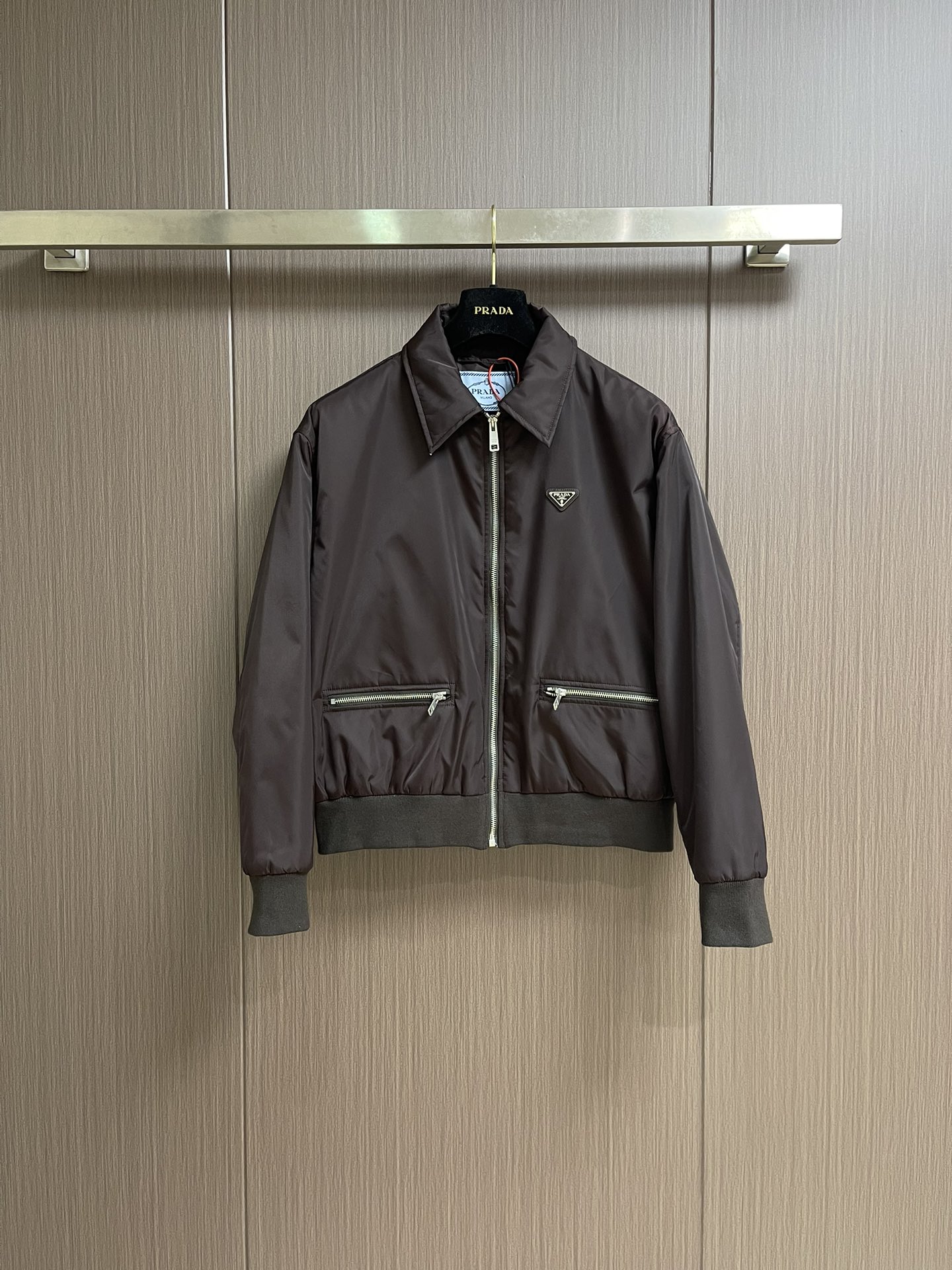 NO:563796,Prada triangular logo zipper pocket cotton jacket, custom-made twill glossy nylon coating material and velvet cloud cotton sheet inside. It is full of texture, comfortable and close to the skin. It is based on a dark coffee tone that has accumulated time. The iconic enamel-coated triangle metal logo embellishment highlights the elegance and nobility of the brand. The lining and padding design highlight the wrapping effect, which cleverly combines the warmth of the cotton jacket with the aesthetics of life. The visual segmentation design of parallel double zipper pockets hides the slim code of the micro-profile, showing elegance and style.  Blooming a unique light. The infrared position of the imported special machine is used to position the 'Prada triangle mark' more accurately, firmly and firmly. Purely manual post-water disassembly process. After completing the initial combination of the lining fabric and the cotton piece, the craftsman will further adjust and disassemble it in the water. The lining fabric and the cotton piece can achieve a perfect combination, making the lining fabric and the cotton piece more closely integrated, beautiful and neat.   Template machine bag opening. The preset template guides the position, shape and size of the bag opening. The accuracy ensures the quality of the bag opening effect. Size 38-40-42-44 S-XL,, prada, alexander wang19860909Prada 三角标拉链口袋棉服 定制斜纹光感尼龙覆膜料 以及内里丝绒云棉片 质感十足 舒适贴肤 以自带时光沉淀的深咖色调作基调 标志性涂珐琅三角形金属徽标点缀 彰显品牌的优雅与高贵 衬里和填充设计凸显包裹效果巧妙融合了棉服的温暖与生活的美学 平行双拉链口袋视觉分割设计 隐藏着微廓形的显瘦密码 尽显优雅风范 绽放独特光芒 采用进口专机红外线定位'Prada三角标'位置更为精准牢固结实 纯手工水后拆卸工艺 完成套里布与棉片的初步结合后匠人会在水中进行进一步的调整和拆卸 套里布与棉片能够实现完美的结合 使得套里布与棉片的结合更为紧密 美观工整 模版机开袋 预设的模板来指导开袋的位置 形状和大小 精确性确保了开袋效果质量.尺码38-40-42-44 S-XL,,prada,alexander wang,Men's clothing