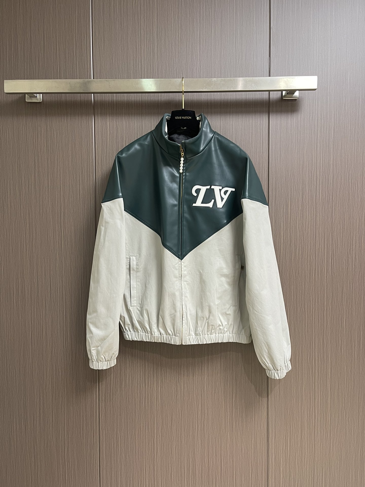 NO:571313,LV  The color-blocked jacket with stand collar is made of bright leather and nylon blended fabrics, which is very cleverly spliced. The leather part uses exquisite cutting technology to create a pointed shape, with clean lines and full of design; the nylon blended fabrics ensure texture and comfort through precise textile technology; the LV intarsia logo adopts 3D three-dimensional intarsia technology, which is full of three-dimensionality and makes the logo highly recognizable; the back collar  The logo uses fine embroidery technology, with fine and even stitching, and the logo is perfectly integrated into the collar design; the elastic hem and cuffs are made with elastic webbing technology, which not only ensures a good fit when worn, but also provides comfortable stretching space during exercise; the beaded zipper puller details are made by hand-made beading inlay technology, making the zipper puller a dazzling decoration, enhancing the overall sense of luxury. Sizes S-XL  46-52,,louis   vuitton,jackets & coats,jackets & coats,alexander wang19860909LV 立领拼色夹克外套,采用亮面皮革与锦纶混纺面料的拼接极具巧思,皮革部分以精湛的裁剪工艺打造出尖角育造型,线条利落且富有设计感；锦纶混纺面料则通过精密的纺织工艺保证了质感与舒适度；LV嵌花标识采用3D立体嵌花工艺,立体感十足,让标识极具辨识度；后领标识运用精细的刺绣工艺,针脚细密均匀,将标识完美融入衣领设计；弹力下摆和袖口采用弹力织带工艺,既保证了穿着时的贴合度,又能在运动时提供舒适的伸展空间；珠饰拉链头细节通过手工珠饰镶嵌工艺,让拉链头成为一处亮眼的装饰,提升了整体的奢华感.尺码S-XL 46-52,,louis vuitton,jackets & coats,jackets & coats,alexander wang,Men's clothing