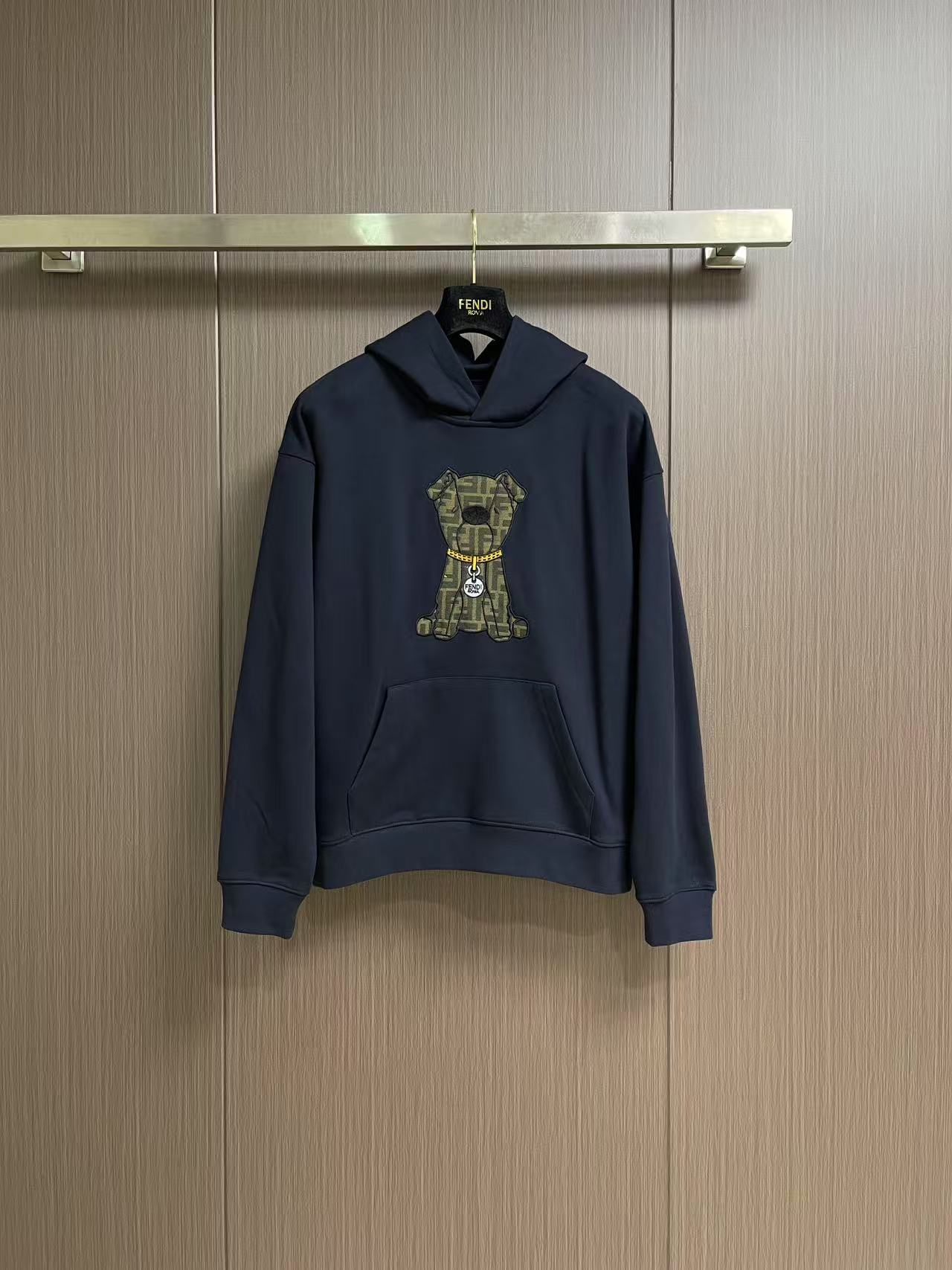 NO:645114,Fendi  The bear embroidered hooded sweatshirt uses a composite structure of 26S double yarn + 10S fish scale bottom. The heavy weight gives the clothing a sculpture-like crispness. The fish scale bottom weave forms a unique concave and convex texture, and after brushing treatment, it appears as skin-friendly as cloud velvet.  Tactile feel. The cuffs and hem are equipped with 21S double yarn 1x1 thread. The ultra-high weight ensures the super elasticity and deformation resistance of the closing area. Innovative use of jacquard weaving + appliqué embroidery + needle embroidery triple process first uses jacquard technology to FF  The pattern is integrated with the brown base fabric; then the main visual hierarchy is built through appliqué positioning; and finally, the edge is precision-wrapped with 16 stitches per inch to realize the seamless integration of the decorative body and the body. The edge strength is increased and the clarity of the pattern outline is enhanced. The loose tailoring of the dropped shoulders breaks through the limitations of the traditional shoulder line and creates a lazy street silhouette.  .The hooded design is matched with the front chest pocket to enhance practical functional attributes. All seams are reinforced with open stitching to ensure that the heavy fabric maintains structural stability during dynamic wear. Sizes XS-L, fendi, hoodie, sweatshirts, hats, alexander  wang19860909Fendi 小熊刺绣连帽卫衣,采用26S双纱＋10S鱼鳞底复合结构,重磅克重赋予衣物雕塑般挺括感.鱼鳞状底层织法形成独特凹凸肌理,经磨毛处理后呈现云绒般亲肤触感.袖口及下摆搭配21S双纱1x1螺纹,超高克重确保收口部位超强回弹性与抗变形能力.创新运用提花织造＋贴布绣＋挨针绣三重工艺先以提花技术将FF 图案与棕色基底织为一体；再通过贴布绣定位构建主视觉层次；最后以每英寸16针的挨针绣精密包边,实现装饰体与衣身的无缝融合,边缘强度提升同时强化图案轮廓的清晰度.落肩宽松剪裁突破传统肩线限制,营造慵懒的街头廓形.连帽设计配合前胸口袋,强化实用机能属性.所有接缝处采用明线锁边加固工艺,确保重磅面料在动态穿着中保持结构稳定.尺码XS-L,,fendi,hoodie,sweatshirts,hats,alexander wang,Men's clothing