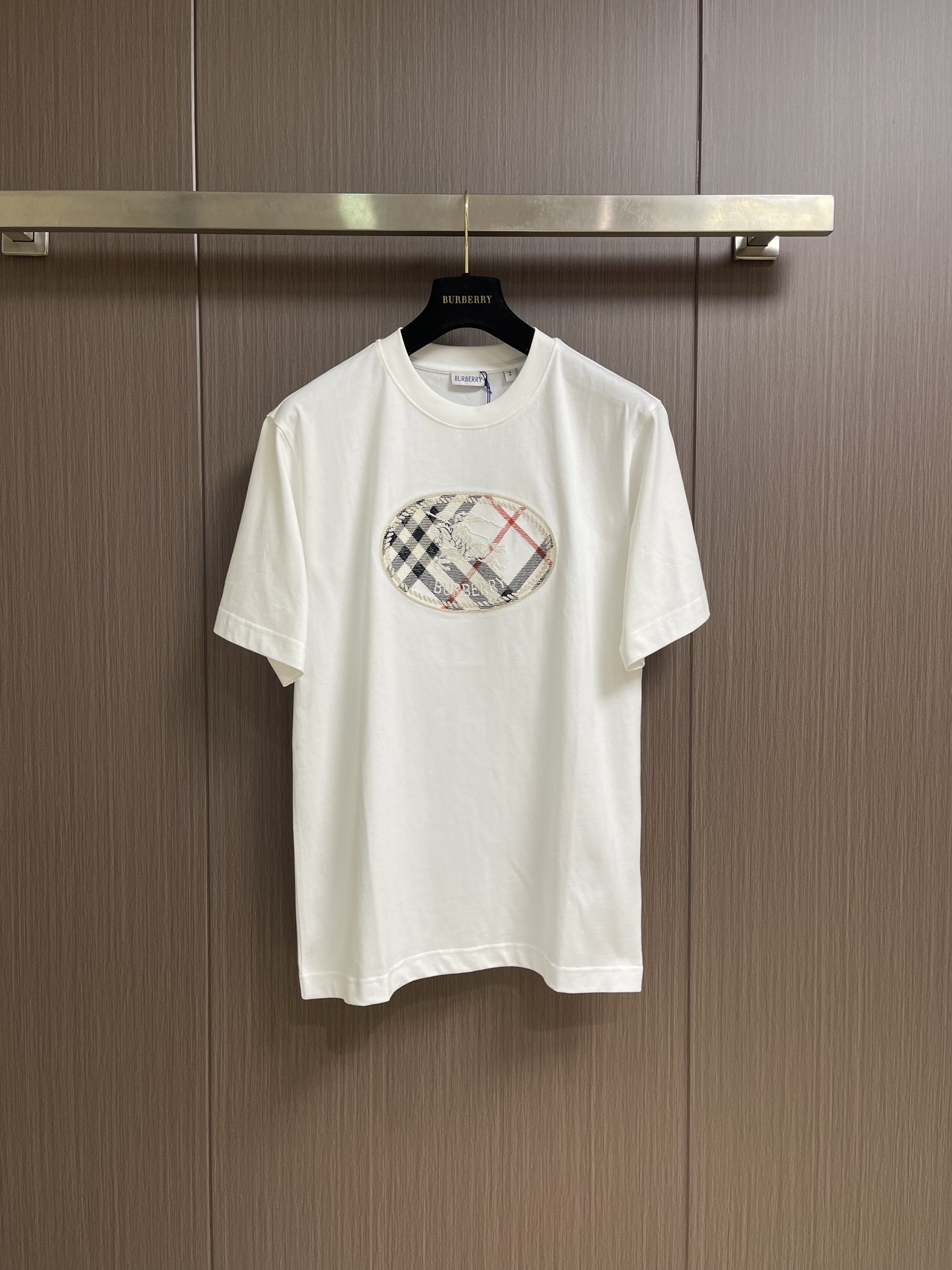 NO:837825,Burberry  The short-sleeved T-shirt with equestrian knight logo plaid print is made of imported high-count combed double-ply plain cotton fabric, which has been processed by pre-shrunk washing process. It feels soft and skin-friendly, has excellent breathable and moisture-absorbing properties, and is not easy to deform and pill after long-term wear. It has a soft drape texture, and the upper body silhouette is neat and not soft. The front of the body is printed with the brand's iconic oval plaid equestrian knight logo. It combines classic plaid elements with knight patterns and uses environmentally friendly reactive dyeing.  Printing technology, high color fastness, not easy to fall off and crack, clearly restore the brand's classic aesthetics; loose shoulder cut version, using ergonomic three-dimensional printing, the shoulder line naturally falls on the shoulders, modifying the head-to-shoulder ratio and body line, and has a high fit regardless of the body shape; the fabric has been specially treated with anti-wrinkle, making it easy to care for daily wear. It can not only create a casual and relaxed daily wear atmosphere, but also adapt to a variety of styles. Size XS-L  XS size bust 104 shoulder width 47 length 71.5 S size bust 108 shoulder width 48.5 length 73.5 M size bust 112 shoulder width 50 length 75.5 L size bust 116 shoulder width 51.5 length 77.5,,burberry,T-shirt,tees,t-shirt,19860909Burberry 马术骑士徽标格纹印花短袖T恤,采用进口高支精梳双股平纹棉面料,经过预缩水洗工艺处理,触感软糯亲肤,兼具优异的透气吸湿性能,久穿不易变形起球,自带柔和垂坠质感,上身廓形利落不软塌；衣身正面采用品牌标志性椭圆格纹马术骑士徽标印花,以经典格纹元素搭配骑士图案,采用环保活性染印技术,色彩牢固度高,不易脱落开裂,清晰还原品牌经典美学；宽松落肩剪裁版型,采用人体工学立体打版,肩线自然落于肩头,修饰头肩比与身形线条,不挑身材适配度高；面料经过特殊抗皱处理,日常穿着打理便捷,既能打造随性松弛的日常穿搭氛围,也能适配多种风格的穿搭场景.尺码XS-L XS码胸围104肩宽47衣长71.5 S码 胸围108肩宽48.5衣长73.5 M码胸围112 肩宽50衣长75.5 L码 胸围116 肩宽51.5 衣长77.5,,burberry,T-shirt,tees，t-shirt,,Men's clothing