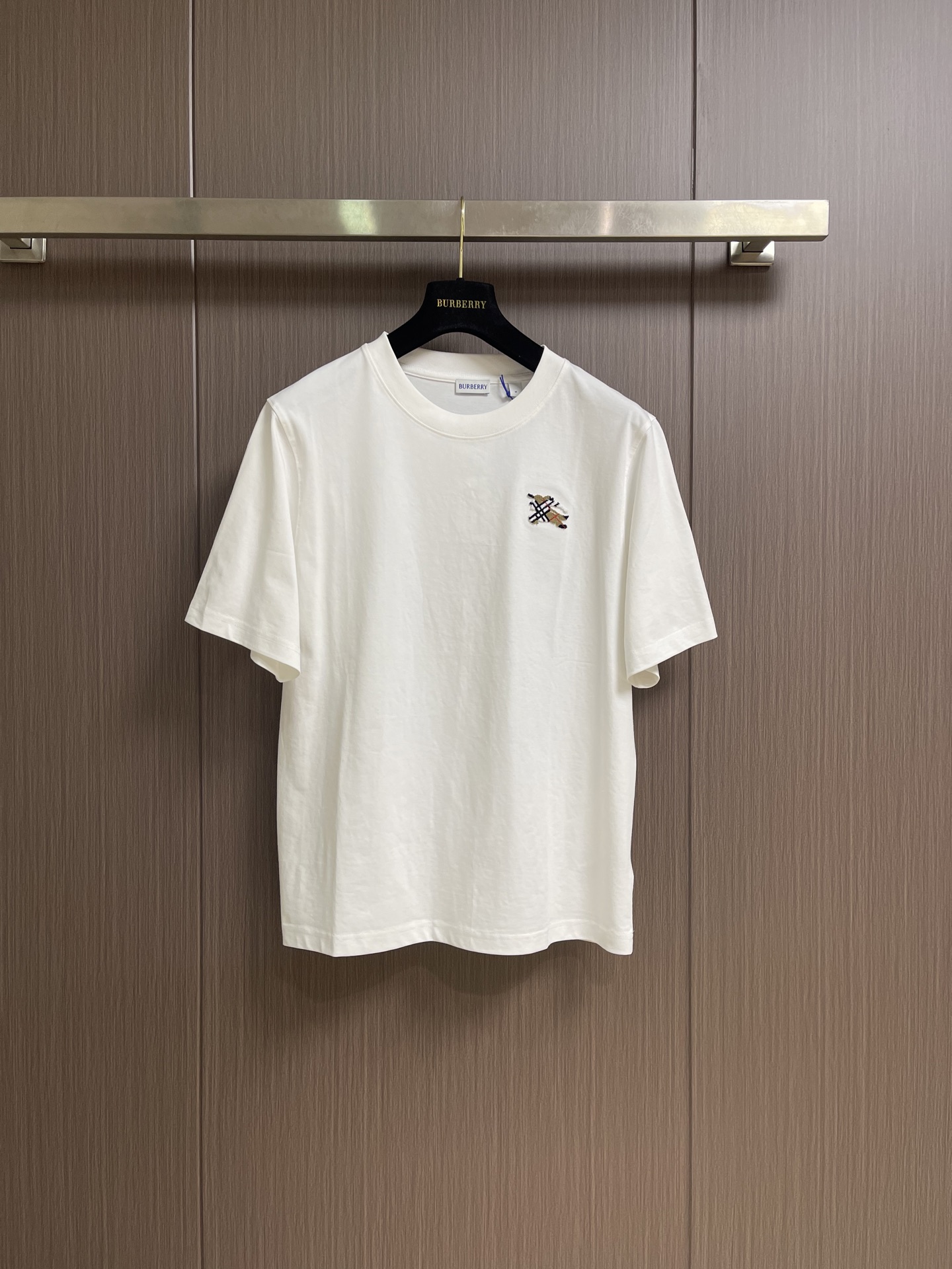 NO:839943,Burberry  Plaid toothbrush embroidered round neck short-sleeved T-shirt, made of 15-count special-spun compact cotton, 230g㎡; matched with 32-count 1×1 rib, 340g㎡. The fabric is a heavy-weight fabric with thick needles, strong texture, and crisp texture. Because the 15-count yarn is thicker, the shaping process is particularly important, as it can eliminate  The internal stress generated during the weaving process of thick yarns prevents pattern misalignment due to shrinkage of the fabric during subsequent multi-layer printing. The collar is made of high-density tight ribbing made of cotton, which is elastic through high-density weaving and has a more pure and natural touch. The equestrian knight logo uses tufted three-dimensional toothbrush thorns.  Embroidery technology, which is characterized by dense and straight piles, soft to the touch like velvet, and clear edge outlines. This is an embroidery technique that uses special needles to embed embroidery threads into bundles into the base fabric, forming an upright-like pile effect. The embroidery needle pierces the fabric with high-speed reciprocating motion, and embroiders multiple strands of embroidery thread simultaneously.  Bring it in and form a coil; after the embroidery is completed, the back is coated with water-based adhesive to fix the bottom of the coil, and the top of the coil is cut and trimmed to a uniform height through a shearing process to form an upright texture similar to toothbrush bristles. The overall wiring is straight and delicate, the fabric is comfortable and soft, and the color is consistent without color difference.  It can be matched with the same style to create a fashionable look, and can be used in various occasions. Customized accessories, complete with three standards, same style for men and women!  Sizes S-XL S size, bust 104, shoulder width 45, length 69, size M, bust 108, shoulder width 46.5, length 71, size L, chest size 112, shoulder width 48, length 73, size XL, chest size 116, width 49.5, length 75, burberry, T-shirt, tees, t-shirt,19860909Burberry 格纹牙刷绣圆领短袖T恤,用15支特纺紧密棉,230g㎡；搭配32支1×1罗纹,340g㎡.面料属于粗针重克重面料,肌理感强、质地挺括.由于15支纱线较粗,定形工序尤为重要,它能消除粗支纱线织造过程中产生的内应力,防止后续多层印花时因面料收缩导致图案错位.衣领属于全棉高密度紧实罗纹,全棉罗纹通过高密度织造实现弹性,触感更加纯粹自然.马术骑士徽标采用簇绒立体牙刷刺绣工艺,该工艺的特点是绒毛密实挺拔、触感柔软如天鹅绒、边缘轮廓清晰.这是一种通过特殊针具将绣线成束植入底布、形成竖立状绒毛效果的刺绣技法.刺绣针以高速往复运动刺穿面料,将多股绣线同时带入并形成线圈；刺绣完成后,背面涂覆水性背胶固定线圈底部,正面则通过剪毛工序将线圈顶部剪开并修剪至统一高度,形成类似牙刷毛束的直立质感.整体走线平直细腻,面料舒适柔软,颜色一致无色差 能与同款搭配营造时尚造型,驾驭各种场合,定制辅料,三标齐全,男女同款！尺码S-XL S码 胸围104肩宽45 衣长69 M码胸围108肩宽46.5 衣长71 L码 胸围112 肩宽48 衣长73 XL码胸围116 肩宽49.5 衣长75,,burberry,T-shirt,tees，t-shirt,,Men's clothing