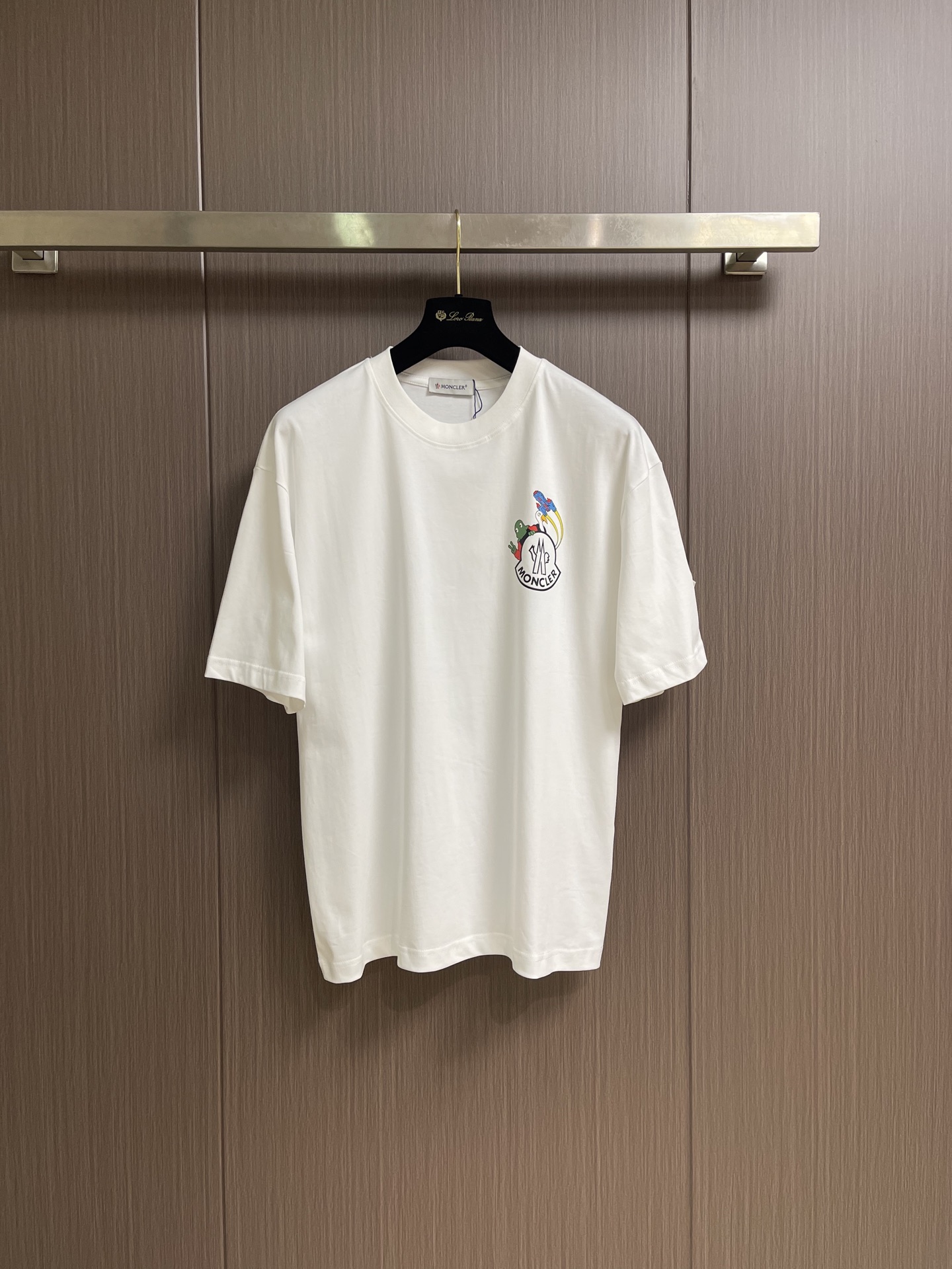 NO:839921,Moncler  Glue printed pattern round neck pullover short-sleeved T-shirt. This white short-sleeved shirt is made of high-count combed cotton fabric, treated with ammonia pre-shrinking and mercerization process. It feels smooth and skin-friendly, breathable and sweat-absorbent and has excellent wrinkle resistance. The color fastness reaches level 4 or above.  , not easy to yellow and deform after long-term washing. The neckline is made of high-elastic ribbing with three-needle hemming technology, which is not easy to loosen and curl after repeated wear; the side seams of the body are made of double-needle embedded clip technology, which ensures smooth and firm routing and reduces skin friction. Chest  The front brand logo adopts imported glue printing process, the pattern is clear and delicate, has strong adhesion and is not easy to crack and fall off; the cuffs and hem adopt flat seam sewing process, the stitching is fine and even, and there are no excess threads. The ready-made garments undergo multiple quality inspection processes such as stitching, ironing and decontamination. The version is loose and comfortable, suitable for daily commuting, leisure travel and other scenes, with both simple texture and practical wearability. The overall wiring is straight and delicate, the fabric is comfortable and soft, and the color is consistent without color difference.  It can be matched with the same style to create a fashionable look, and can be used in various occasions. Customized accessories, complete with three standards, same style for men and women!  Sizes M-XXL M size bust 110 shoulder width 51.5 length 71 L size bust 114 shoulder width 52.5 length 7319860909Moncler 胶浆印花图案圆领套头短袖T恤,这款白色短袖采用高支精梳棉面料,经氨预缩与丝光工艺处理,触感柔滑亲肤,透气吸汗且抗皱性优异,色牢度达4级以上,久洗不易发黄变形.领口采用高弹力罗纹搭配三本针包边工艺,反复穿着不易松弛卷边；衣身侧缝采用双针埋夹工艺,走线平整牢固,减少皮肤摩擦感.胸前品牌标识采用进口胶浆印刷工艺,图案清晰细腻、附着力强,不易开裂脱落；袖口与下摆采用平缝锁边工艺,针脚细密均匀,无多余线头.成衣经针、整烫、去污等多道质检工序,版型宽松舒适,适配日常通勤、休闲出游等多种场景,兼具简约质感与实穿性.整体走线平直细腻,面料舒适柔软,颜色一致无色差 能与同款搭配营造时尚造型,驾驭各种场合,定制辅料,三标齐全,男女同款！尺码M-XXL  M码 胸围110 肩宽51.5 衣长71 L码 胸围114 肩宽52.5 衣长73  XL码 胸围118 肩宽53.5 衣长75 XXL码 胸围122 肩宽54.5 衣长76,,T-shirt,tees，t-shirt,,Men's clothing