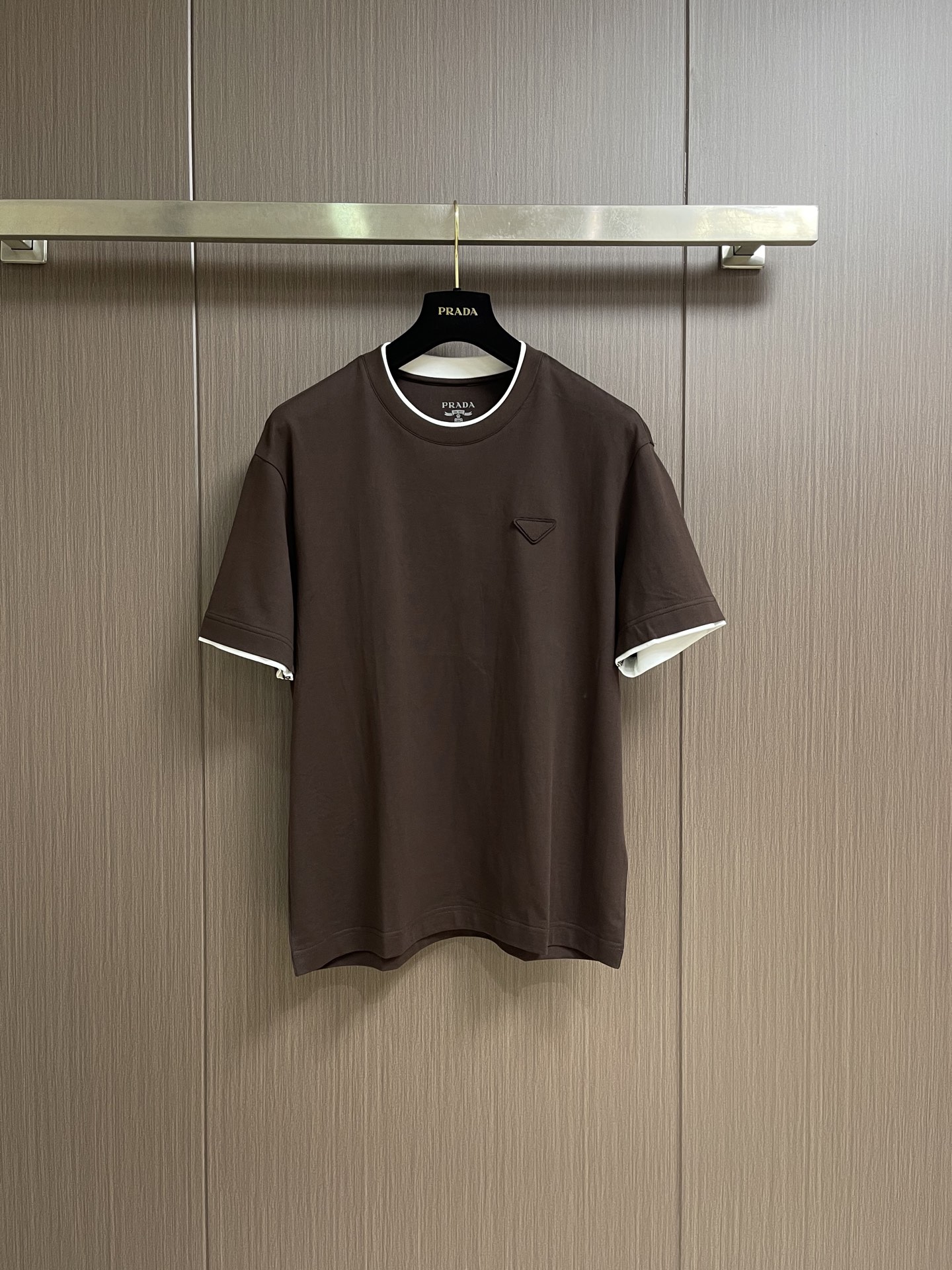 NO:842694,PRADA  Logo fake two-piece round neck short-sleeved T-shirt. The fabric is made of 24S special-spun compact cotton with 220g 40S double yarn thread. The compact spinning process makes the yarn highly powerful, the fibers are tightly arranged, the appearance is smooth and hairy, and it is not easy to sand. The basic version of the classic round neck adopts a fake two-piece structure with a double-layer neckline and an asymmetric hem.  The stitching creates a three-dimensional box-shaped outline, and the collision and overlapping of color blocks create a visual dislocation effect. The design is novel and unique; the triangular logo on the front chest is formed by heat-pressing and compounding to form a three-dimensional thickness. It is woven with woven yarn raw materials and laser cut to restore it. The overall wiring is straight and delicate, ensuring comfortable wearing, and the fabric color is consistent without color difference!  Size 48-56,,prada,T-shirt,tees,t-shirt,19860909PRADA 标识假两件圆领短袖T恤,面料采用24S特纺紧密棉,搭配40S双纱螺纹220g,紧密纺工艺使纱线强力高、纤维排列紧密、外观光洁毛羽少不易磨毛;经典圆领基础版型采用双层领口与不对称下摆的假两件结构,侧缝线塑造立体箱型轮廓,色块碰撞叠搭营造视觉错位效果,设计新颖独特;前胸三角徽标通过热压复合形成立体厚度,采用梭织成份纱线原料编织并激光切割还原,整体走线平直细腻,确保穿着舒适,且面料颜色一致无色差! 尺码48-56,,prada,T-shirt,tees，t-shirt,,Men's clothing