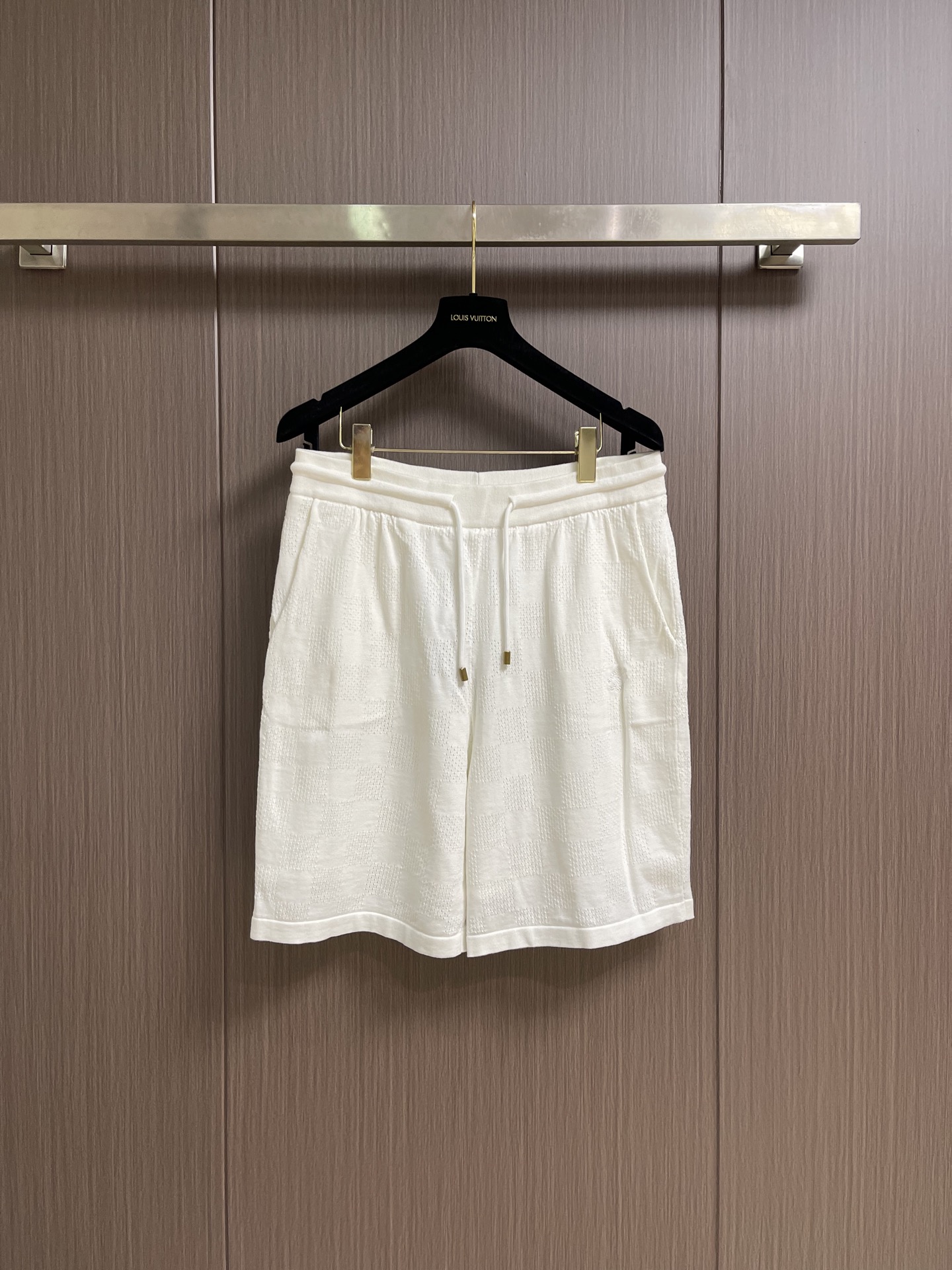 NO:845206,LV  The embossed checkerboard terry shorts are made of the original custom-made soft cotton blended terry luxury fabric. The texture is clear, plump and lazy, comfortable and close to the skin. The white tone is as calm and deep as the deep sea. The full-width checkerboard embossing uses three-dimensional relief techniques, using a high-density electronic jacquard machine to achieve a three-dimensional effect with 'positive and negative layer weaving', and then customized  The mold is hot-pressed to hot-melt the fibers in specific areas and permanently shape the relief contours with an accuracy of micron level. The fabric is washed and has a better hand texture, which is not easy to deform, shrink and fade, and maintains long-term beauty. It is custom-woven and dyed, without any color difference from the original version. The craftsmanship is perfectly restored, three standards are complete, and customized accessories. Sizes S-XL  46-52 Size 46 waist 76 leg opening 33 pants length 49 48 size waist 78 leg opening 34 pants length 51 50 size waist 80 leg opening 35 pants length 52 52 size waist 82 leg opening 36 pants length 54,,louis vuitton,shorts,19860909LV 压纹棋盘格毛圈短裤,面料采用原版一致定制臻柔棉混纺毛圈奢绮布,纹理清晰,丰满慵懒,舒适贴肤,白色基调似深海般沉静深邃.全幅棋盘格压纹采用立体浮雕技法,通过高密度电子提花机以“正负层织法”实现立体效果,再以定制模具热压使特定区域纤维热熔粘合,永久定型浮雕轮廓,精度达微米级别.面料经浇洗处理,手感质感更佳,不易变形、缩水与褪色,保持长久美观.定织定染,与原版无任何色差.匠心工艺完美还原,三标齐全,定制辅料.尺码S-XL 46-52 46码腰围76 脚口33裤长49 48码腰围78 脚口34裤长51 50码腰围80 脚口35裤长52 52码腰围82 脚口36裤长54,,louis vuitton,shorts,,Men's clothing