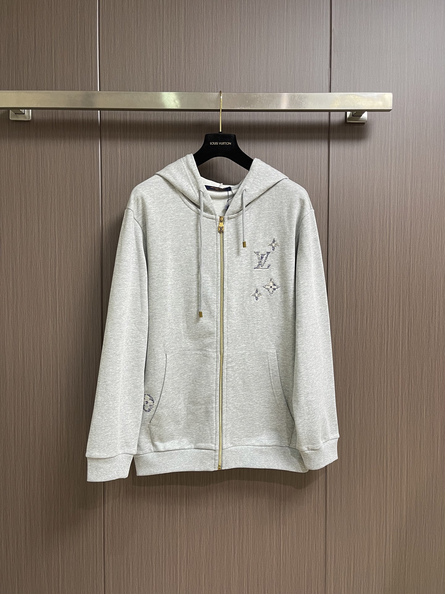NO:845265,LV  The hooded zipper sweatshirt with embroidered logo is made of heavy terry knitted fabric. The texture is thick and soft, feels skin-friendly and breathable. It has excellent warmth retention and drape. The upper body is comfortable and comfortable, and it is not easy to pill and deform after long-term wear. The whole body of the garment is made of delicate embroidery technology, inspired by the brand's iconic Monogram elements, to create exquisite LV letters and flower logo embroidery. The stitching is fine and smooth, and the color transition is natural, keeping a low profile.  It shows a luxurious texture; the placket adopts a customized metal zipper with the brand logo engraved on the zipper pull, which opens and closes smoothly and has a full texture; there is a large-sized kangaroo pocket on the front, with neat and tight routing, which is practical and adds a sense of layering to the body; the cuffs and hem are made of ribbed edge technology, which is moderately elastic, comfortable to wear without being tight, and can effectively prevent wind and heat; the loose-shoulder cut is not flattering on the figure. Sizes S-XL, Louis  vuitton,hoodie,sweatshirts,hats,19860909LV 刺绣标识连帽拉链卫衣,采用重磅毛圈针织面料,质地厚实软糯,触感亲肤透气,兼具出色保暖性与垂坠感,上身舒适自在,久穿不易起球变形；衣身通体采用细腻刺绣工艺,以品牌标志性Monogram元素为灵感,打造精致的LV字母与花卉标识刺绣,针脚细密平整,色彩过渡自然,低调中尽显奢华质感；门襟采用定制金属拉链,拉链头刻有品牌标识,开合顺滑流畅,质感十足；正面设有大尺寸袋鼠口袋,走线工整紧密,实用之余增添衣身层次感；袖口与下摆采用罗纹收边工艺,弹性适中,穿着舒适不勒身,同时能有效防风锁温；宽松落肩版型剪裁不挑身材.尺码S-XL,,louis vuitton,hoodie,sweatshirts,hats,,Men's clothing