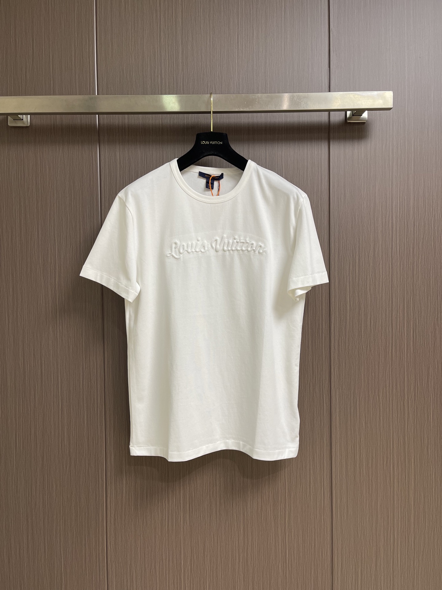 NO:845216,LV  The three-dimensional wave letter short-sleeved T-shirt is made of 15-count special-spun compact cotton with 32-count 1x1 rib. The 15-count yarn is thicker, with strong texture and crisp texture. The cotton fiber is mercerized to enhance the gloss and smoothness, and the background color is full and even. It is then shaped and stretched at high temperature to eliminate wrinkles and internal stress. The 32-count rib collar retracts to the best elastic state and fits well. The handwritten logo on the chest  Three-dimensional core-spun embroidery is used, with core cotton as the base, and the outer layer of embroidery thread is tightly wrapped, giving the letters a rounded and raised three-dimensional effect. The thick-line outline lock edge is reinforced along with the letter outline to strengthen the border clarity and enhance the visual hierarchy. Box-shaped straight cut, precise shoulder line, H-shaped straight body, square and neat outline, and the right-angled outline is maintained after multiple washes. Customized accessories, complete with three standards, the original version is developed only to restore!  Size S-XL S size bust 106 shoulder width 47 length 68 M size bust 110 shoulder width 49 length 69.5 L size bust 114 shoulder width 51 length 7119860909LV 立体浪花字母短袖T恤,采用15支特纺紧密棉,搭配32支1x1罗纹.15支纱线较粗,肌理感强,质地挺括.棉纤维经丝光处理,光泽度与平滑感增强,底色饱满匀净.后经高温定型拉幅,消除褶皱与内应力.32支罗纹领口回缩至最佳弹性状态,贴合不勒.胸前手写体标识采用立体包芯刺绣,以芯棉为底,外层绣线紧密包裹,字母呈圆润隆起立体效果.粗线廓形锁边沿字母轮廓加固,强化边界清晰度,增强视觉层次.箱型直身剪裁,肩线精准,衣身呈H型直筒,轮廓方正利落,多次洗涤后保持直角轮廓感.定制辅料,三标齐全,原版开发只为还原！尺码S-XL S码胸围106 肩宽47 衣长68 M码 胸围110肩宽49 衣长69.5 L码胸围114肩宽51 衣长71 XL码 胸围118肩宽53 衣长72.5,,louis vuitton,T-shirt,tees，t-shirt,,Men's clothing
